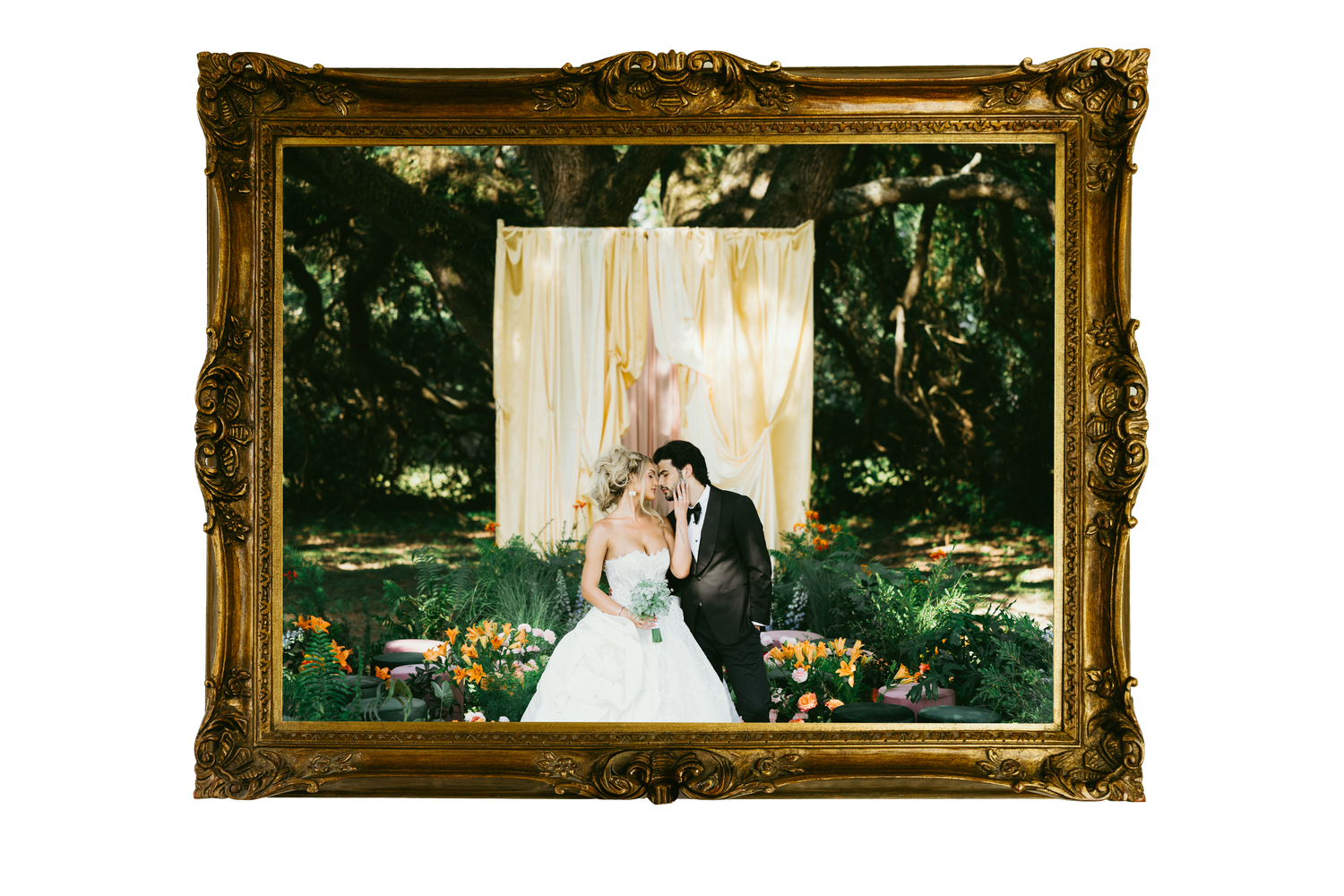 Bride and groom kissing in an ornate gold frame with lush garden backdrop and floral decor.