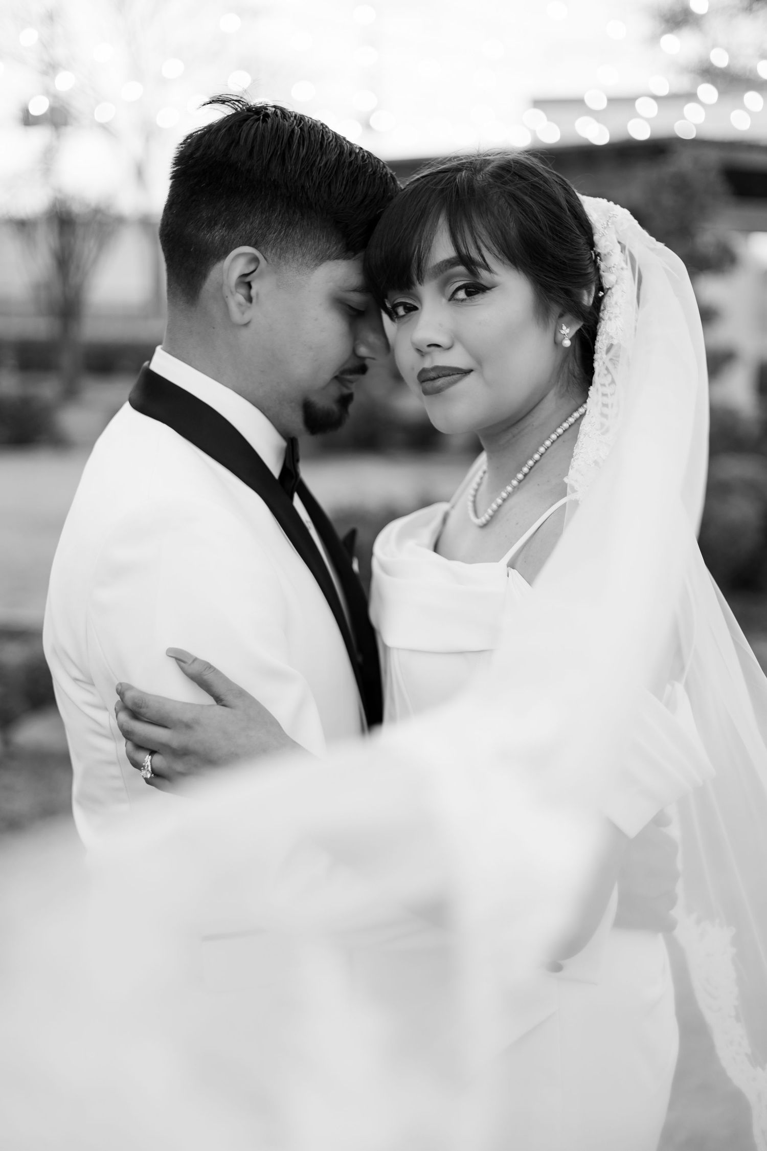 A black and white series of romantic wedding photos showing tender moments between a bride and groom.