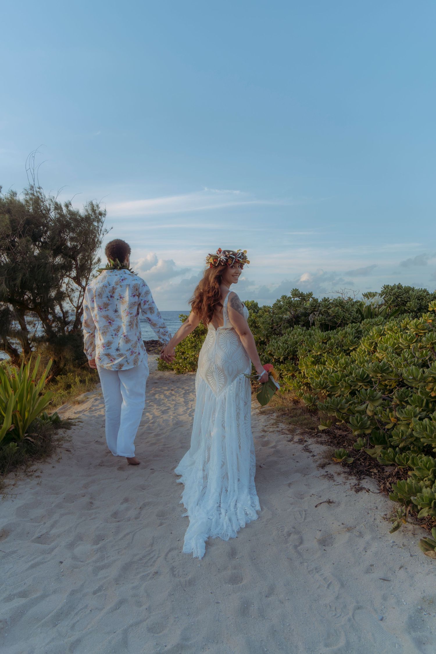Holding hands and walking on a quiet Hawaiian beach at sunset