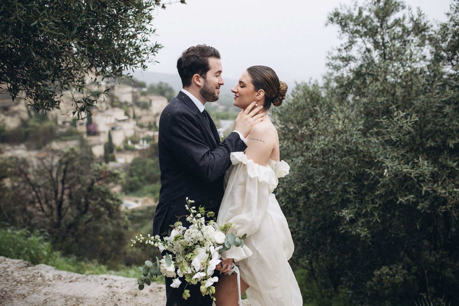 Photographie Mariage en Provence  Séance photo couple se tenant face à Gordes dans le Vaucluse