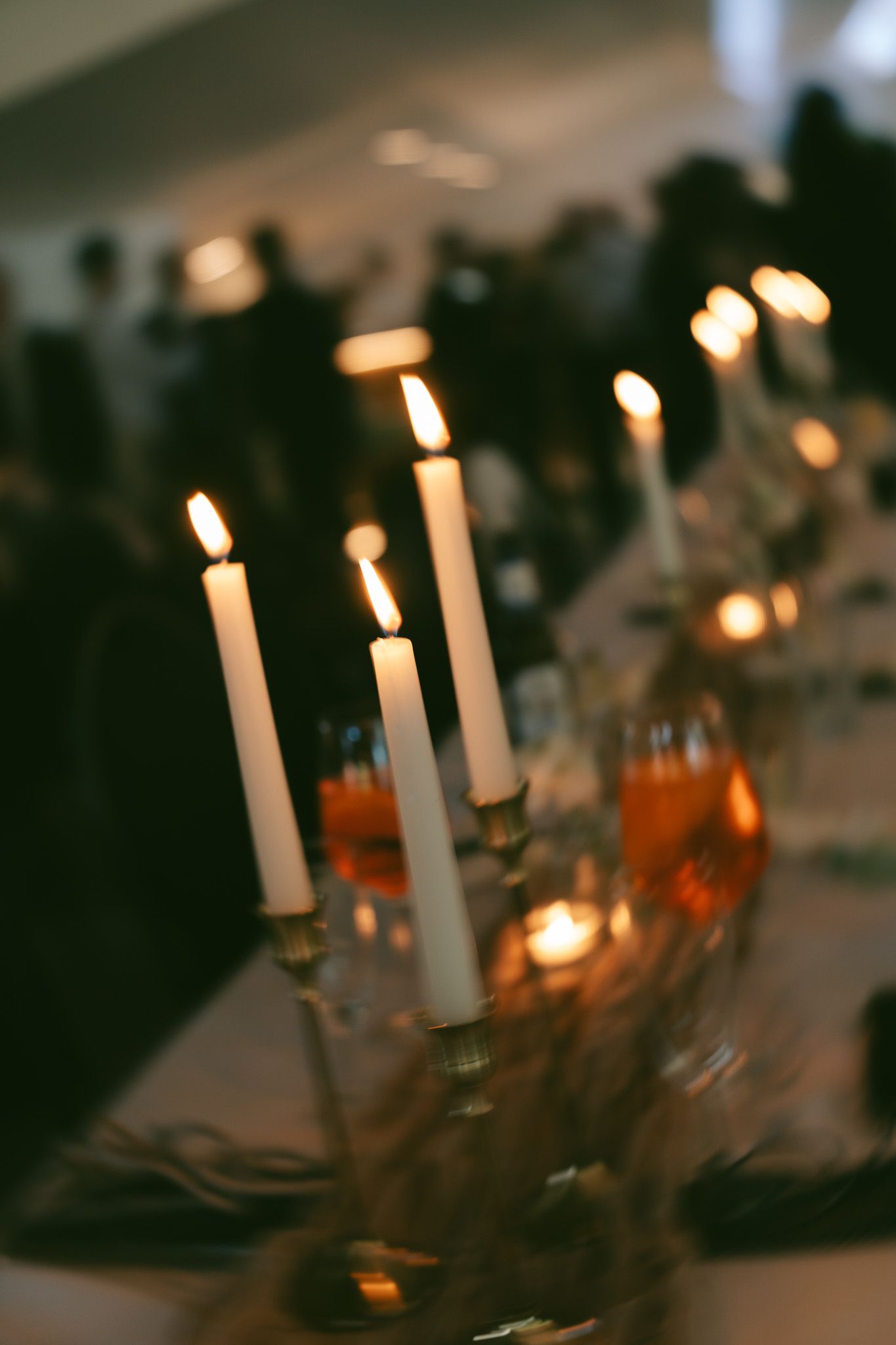 Elegant wedding reception table setting with glowing candles and romantic ambient lighting.