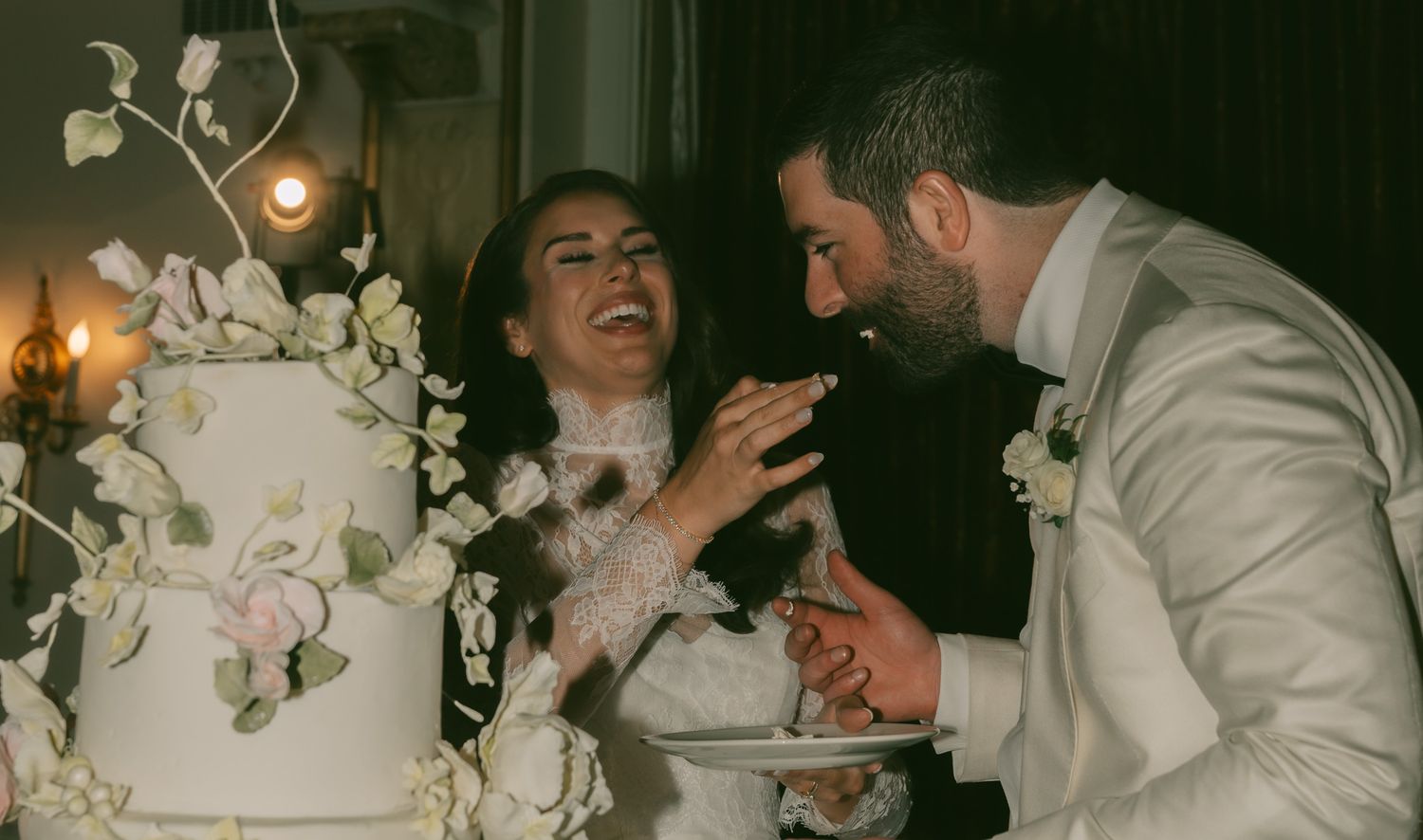 Playful moment of cake feeding between newlyweds at their reception in downtown pittsburgh, pa..
