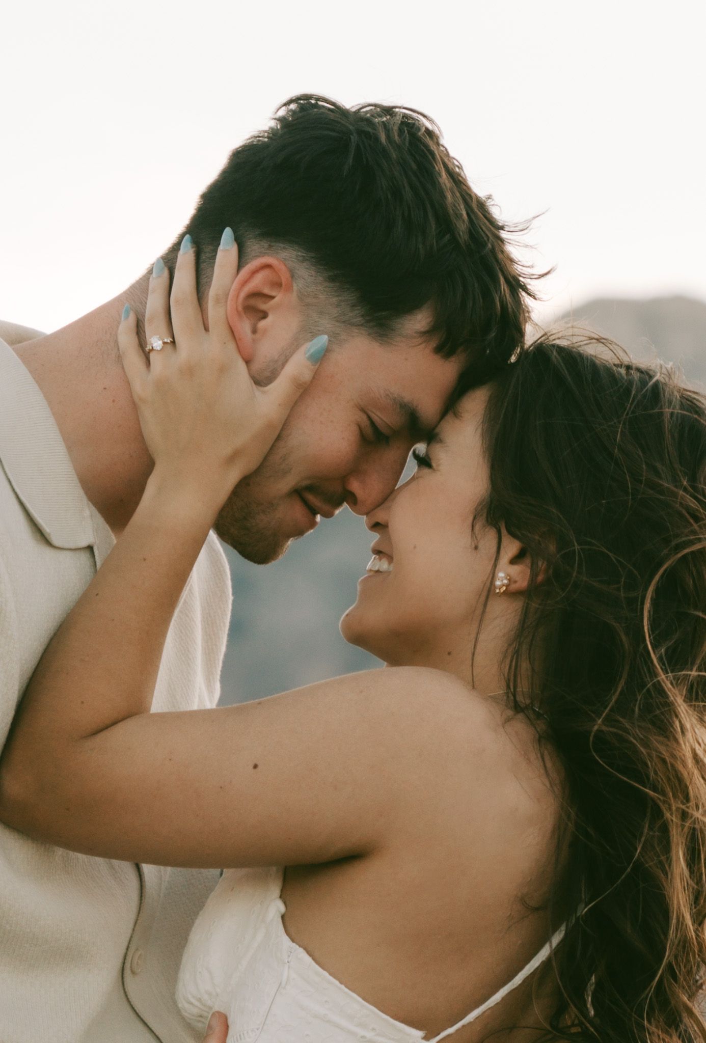 A romantic couple embraces tenderly in a series of soft, warm-toned photos showing their intimate connection in red rock canyon, las vegas.