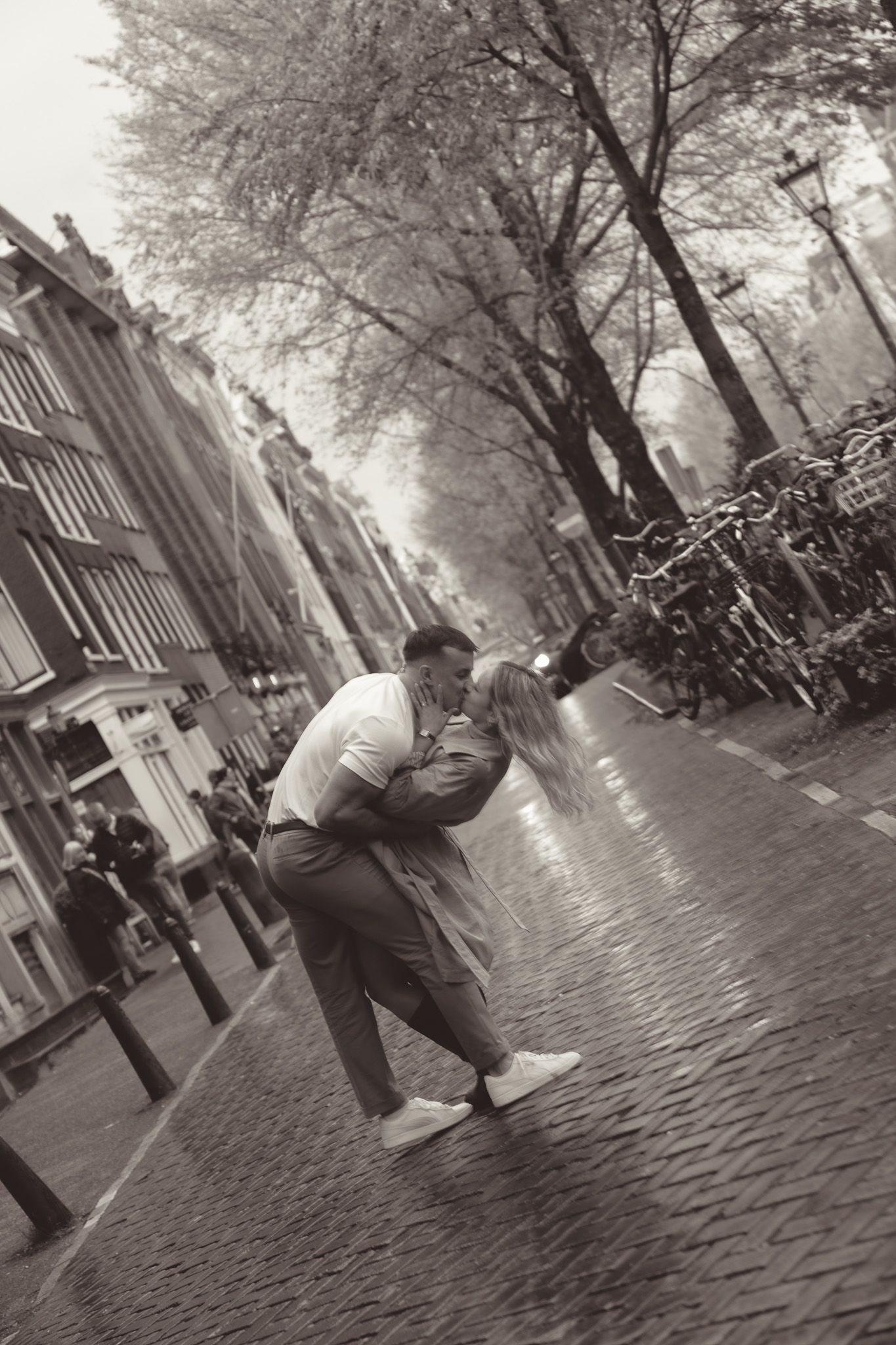 Black and white romantic photo series on cobblestone streets of Amsterdam.