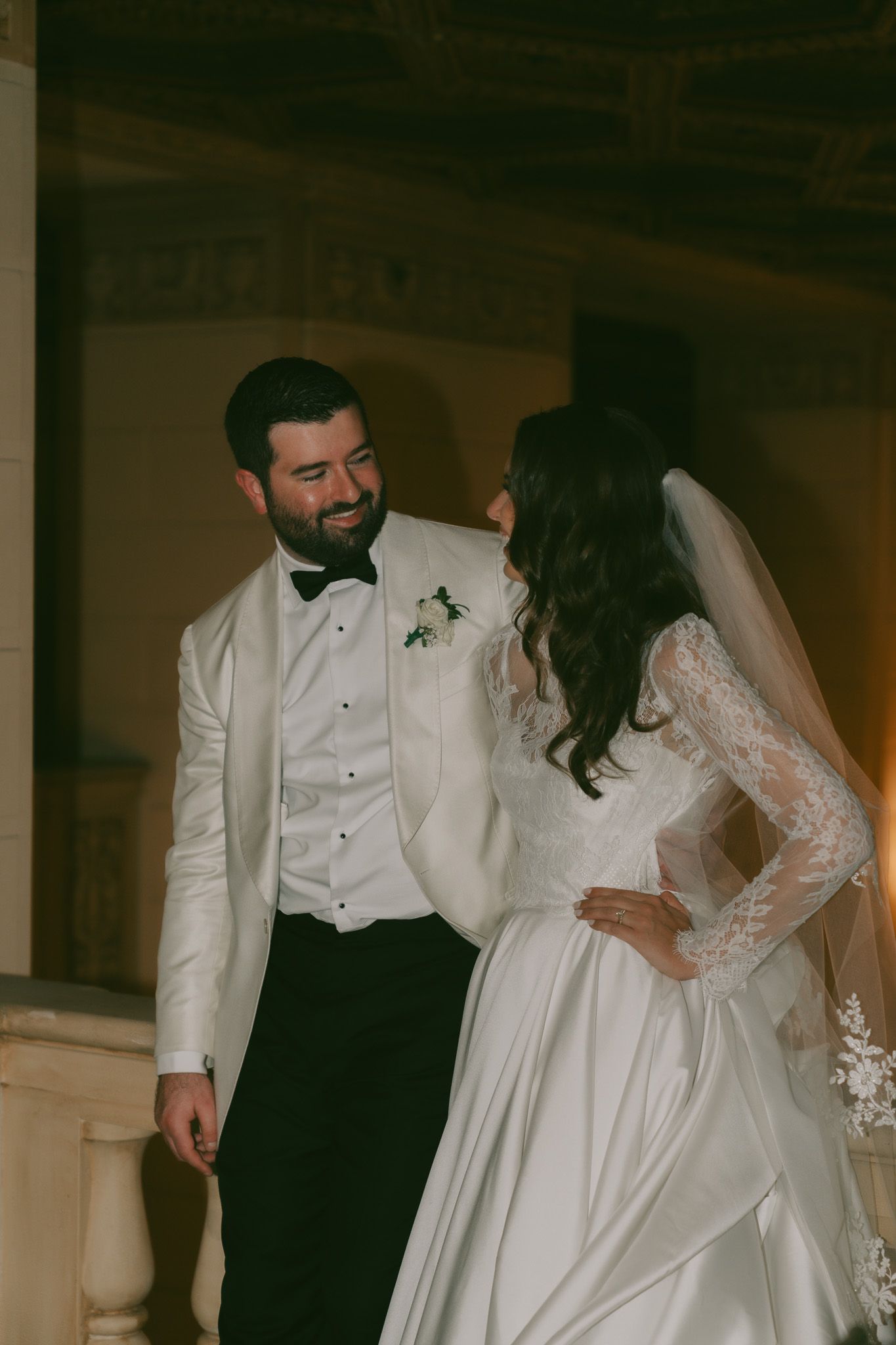 A romantic moment captured between newlyweds in formal attire against a dark interior backdrop in downtown pittsburgh, pa.
