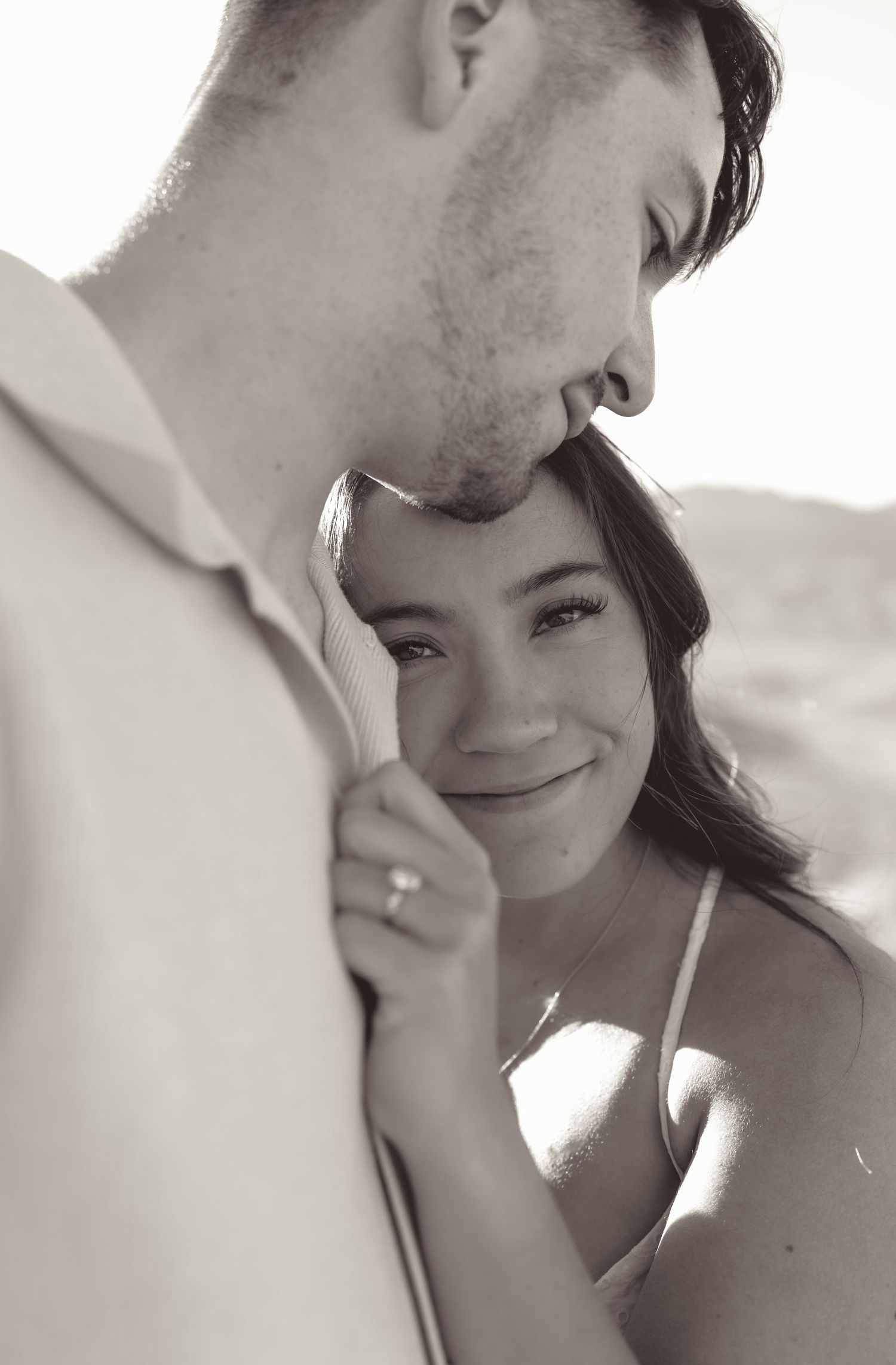 Intimate black and white engagement portrait of couple sharing tender moment in soft lightingin las vgeas NV.