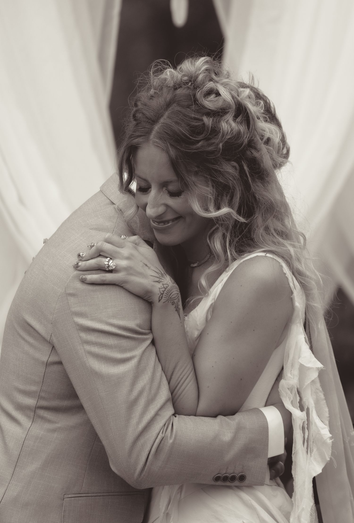 Intimate black and white portrait of couple sharing tender moment at wedding reception.
