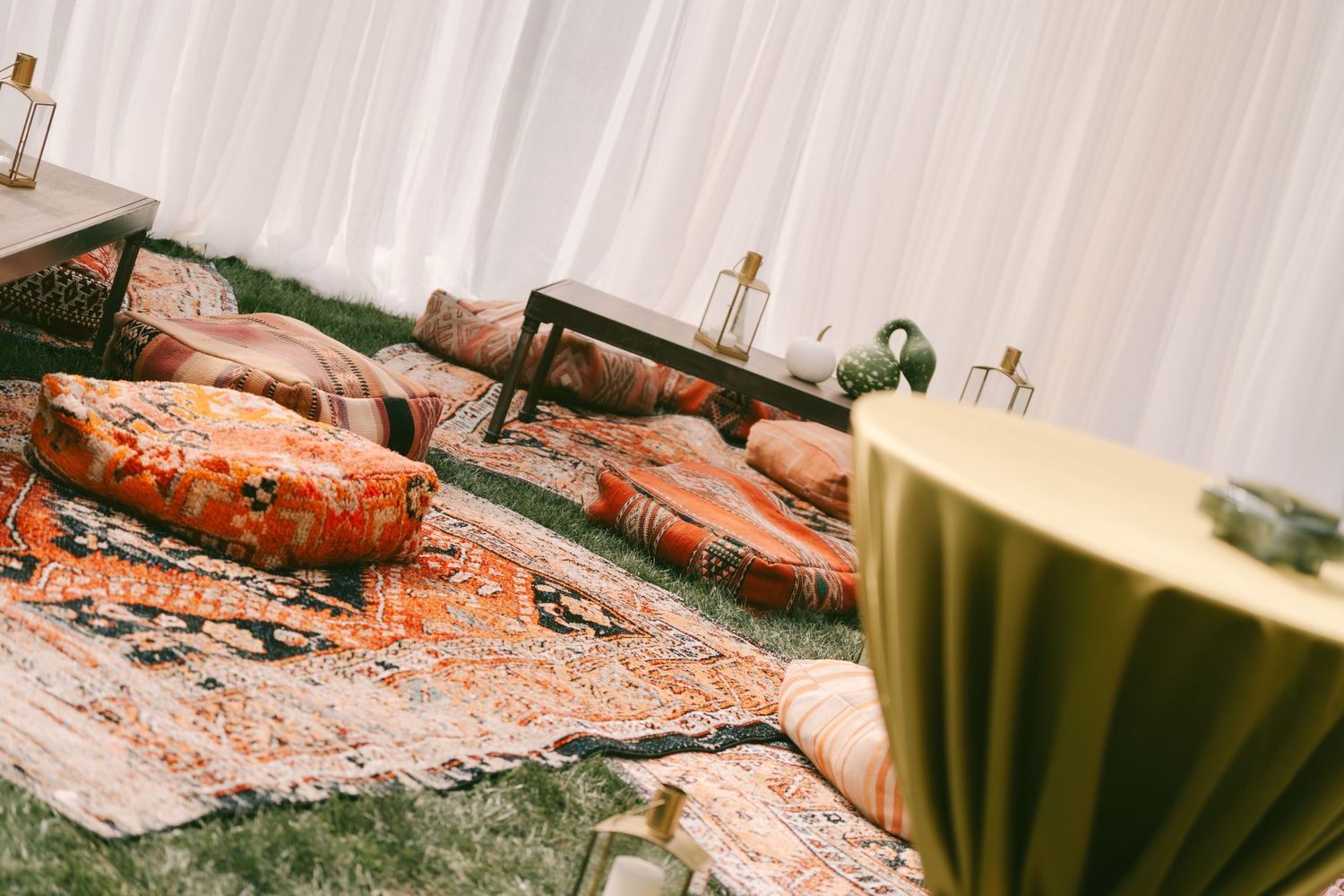 Decorative coral and peach colored table settings at an outdoor event.