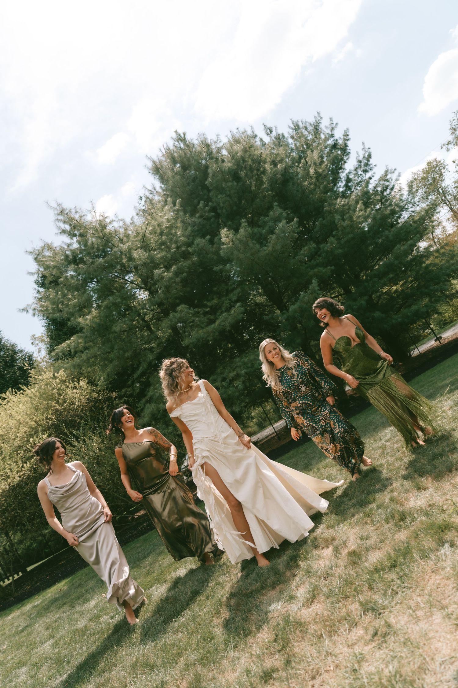 A sequence of playful dance poses captured on a grassy hillside with trees in the background.