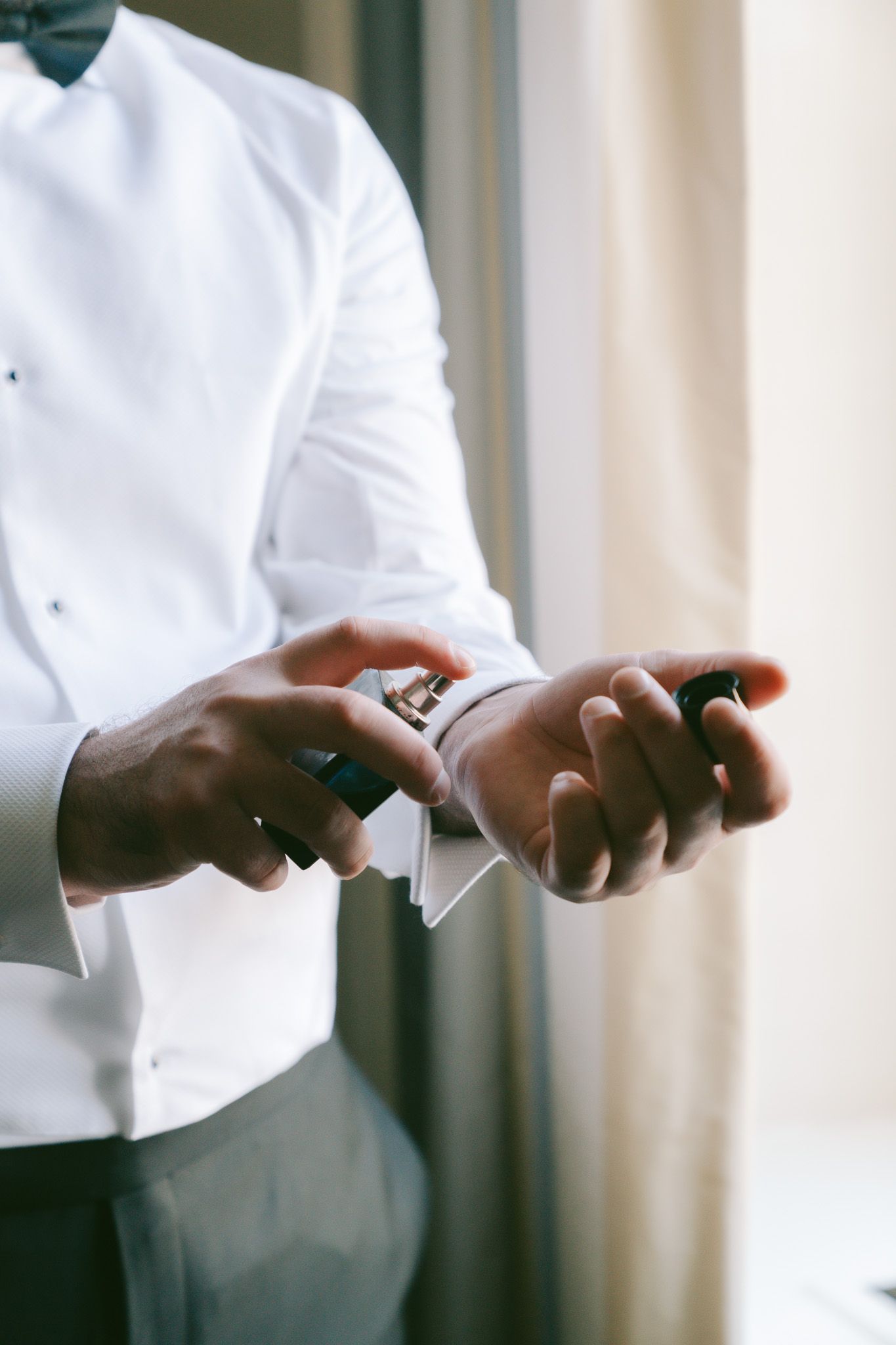 Close-up of hands adjusting cufflinks on a crisp white tuxedo shirt in downtown pittsburgh, pa..