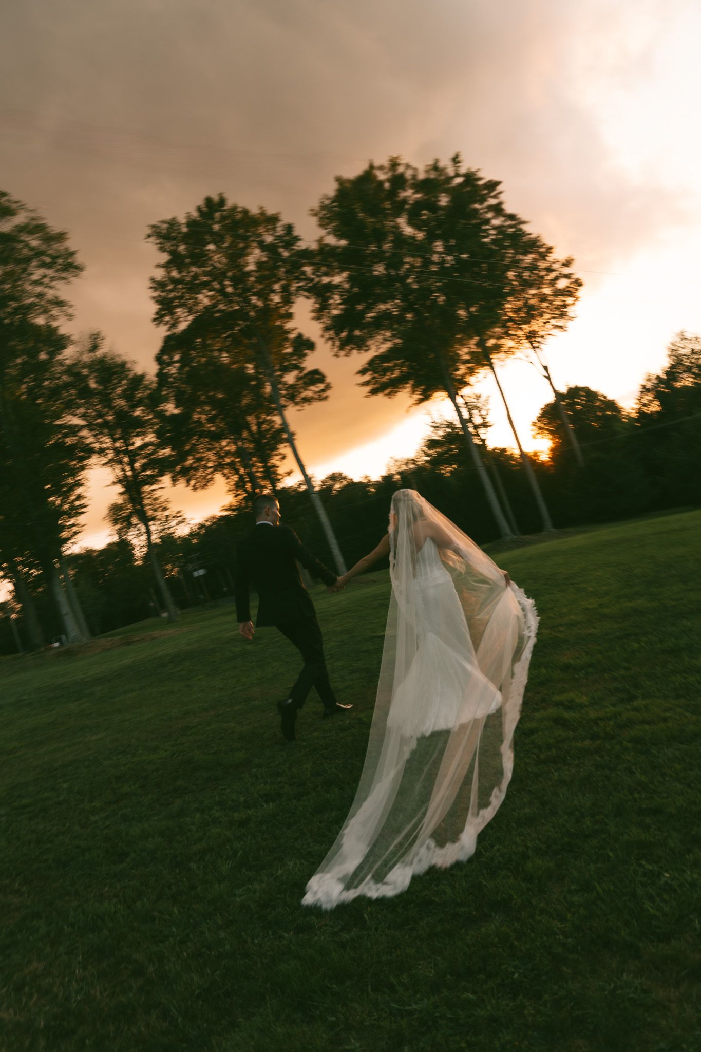 Ethereal figure in flowing white veil dances across a hillside at sunset against silhouetted trees  in isle of skye scotland