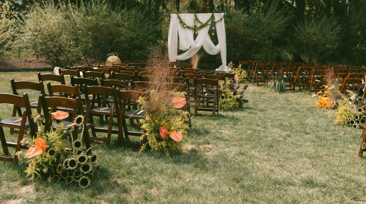Rustic autumn scene with pumpkins and gourds displayed on wooden crates in a garden setting.