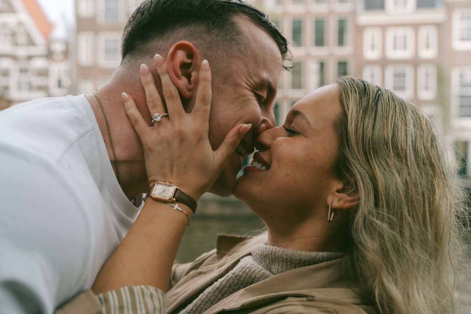Intimate moment shared between couple against vintage European architecture Amsterdam.