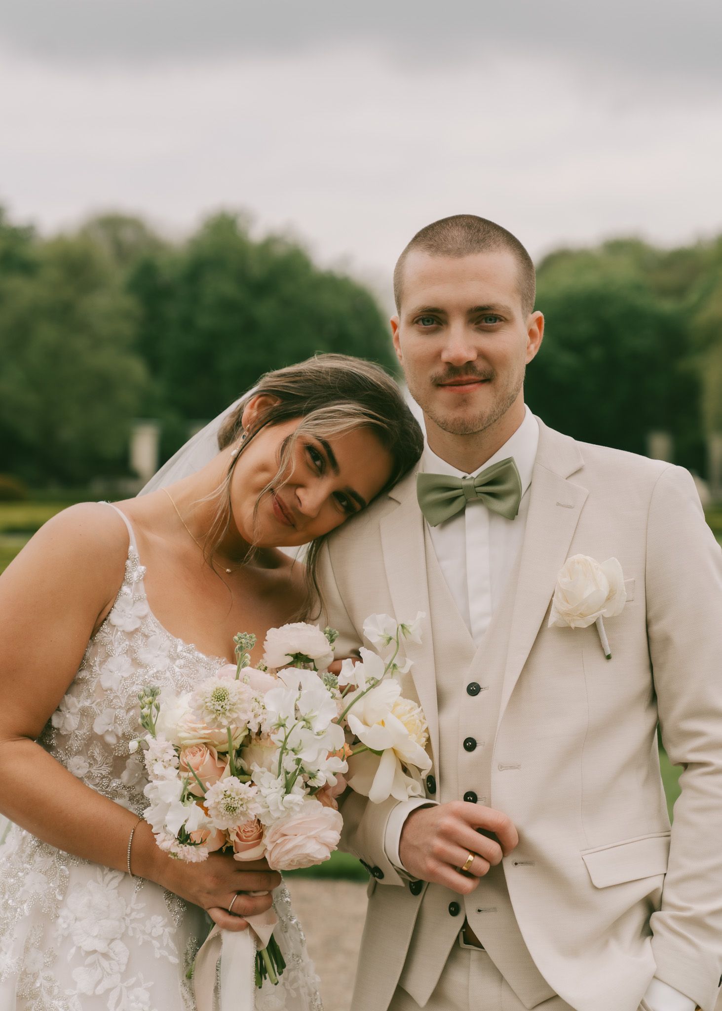An intimate wedding portrait showing a couple in white attire with delicate floral bouquets in Germany.