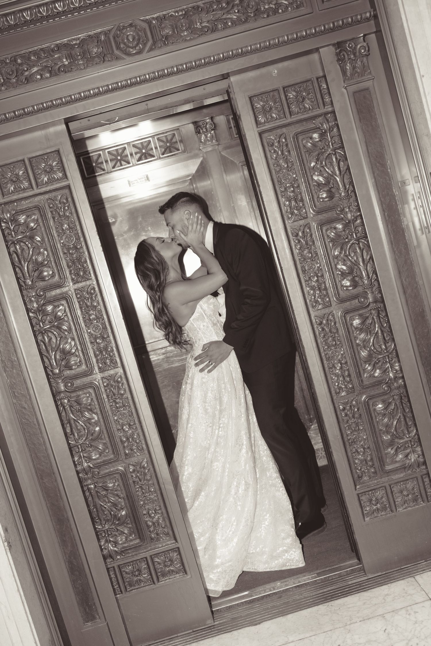 Wedding couple dancing in an elegant ballroom with ornate carved wooden panels and decorative details.