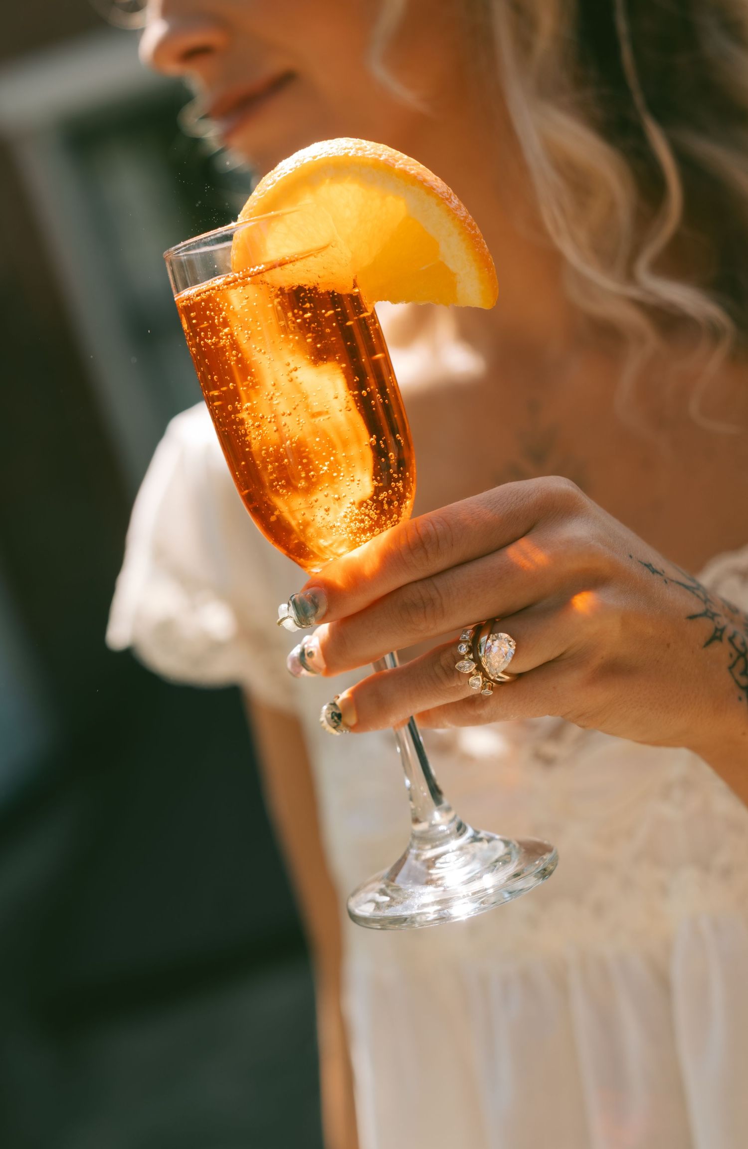 Close-up of a sparkling cocktail with an orange garnish in a stemmed glass.