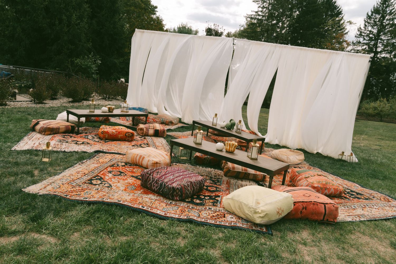 Rustic outdoor seating arrangement with wooden benches and cushions set up for a casual gathering.