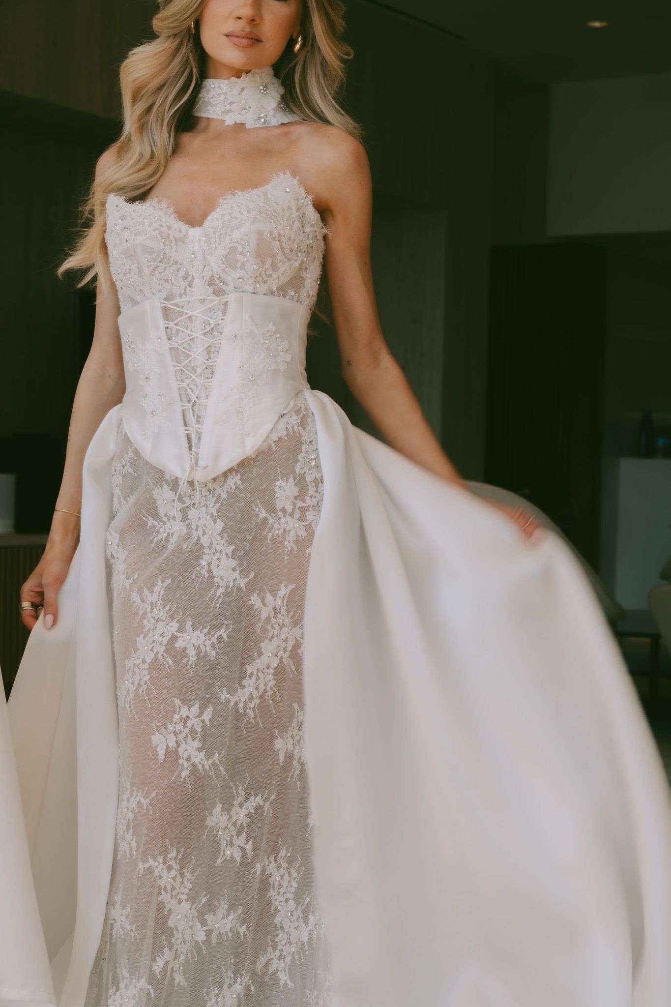 Delicate lace Eden Aharon wedding dress with sheer bodice and flowing white fabric details.