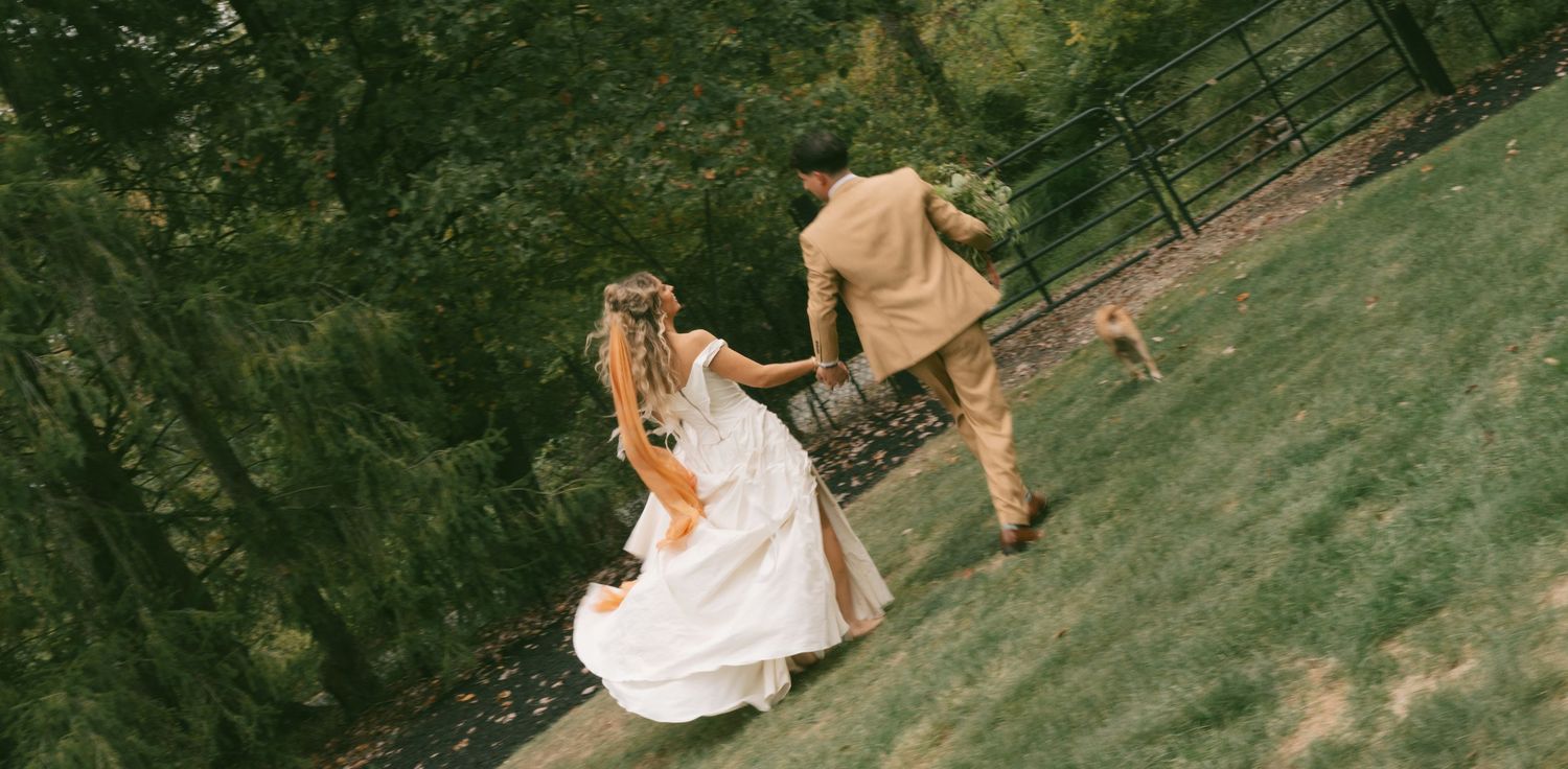 A couple poses together during an outdoor wedding photoshoot in a lush green garden setting.