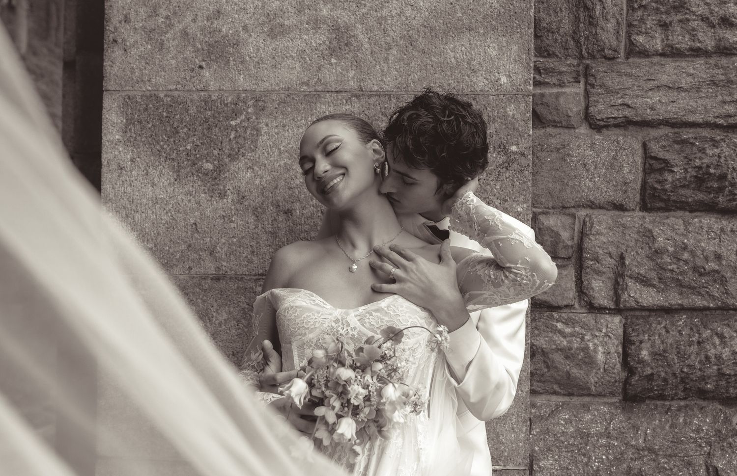Black and white sequence of romantic wedding moments against a stone wall.