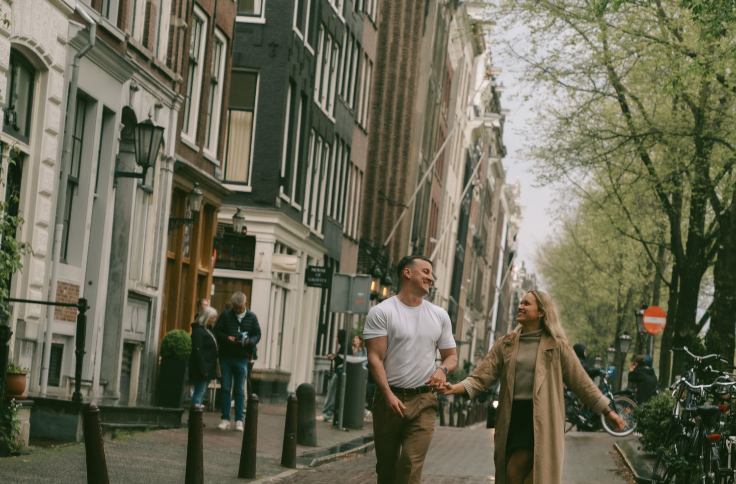 Romantic scene on a historic Amsterdam street with classic Dutch architecture in the background.