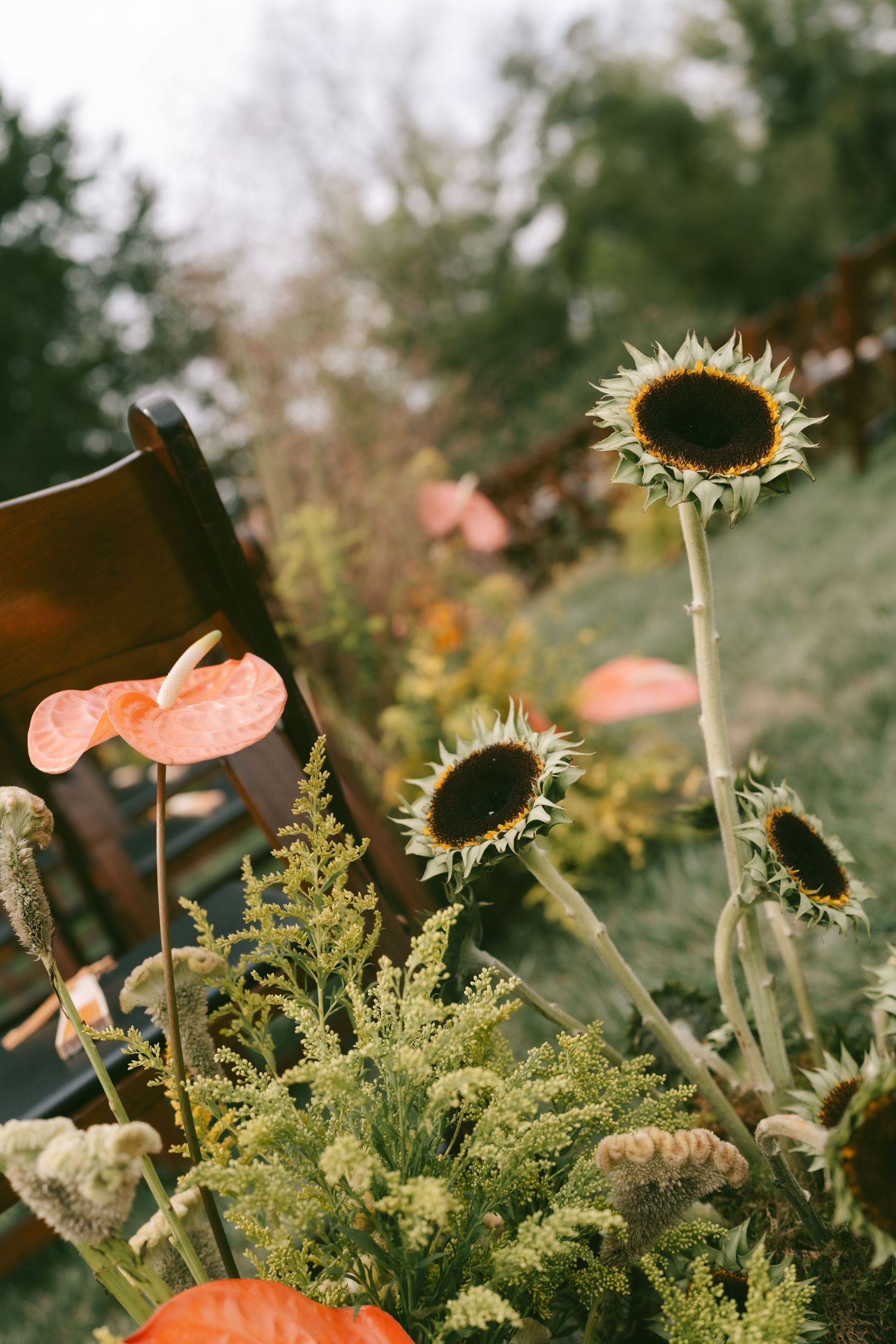 Garden decoration featuring dried sunflowers and natural greenery for outdoor wedding.