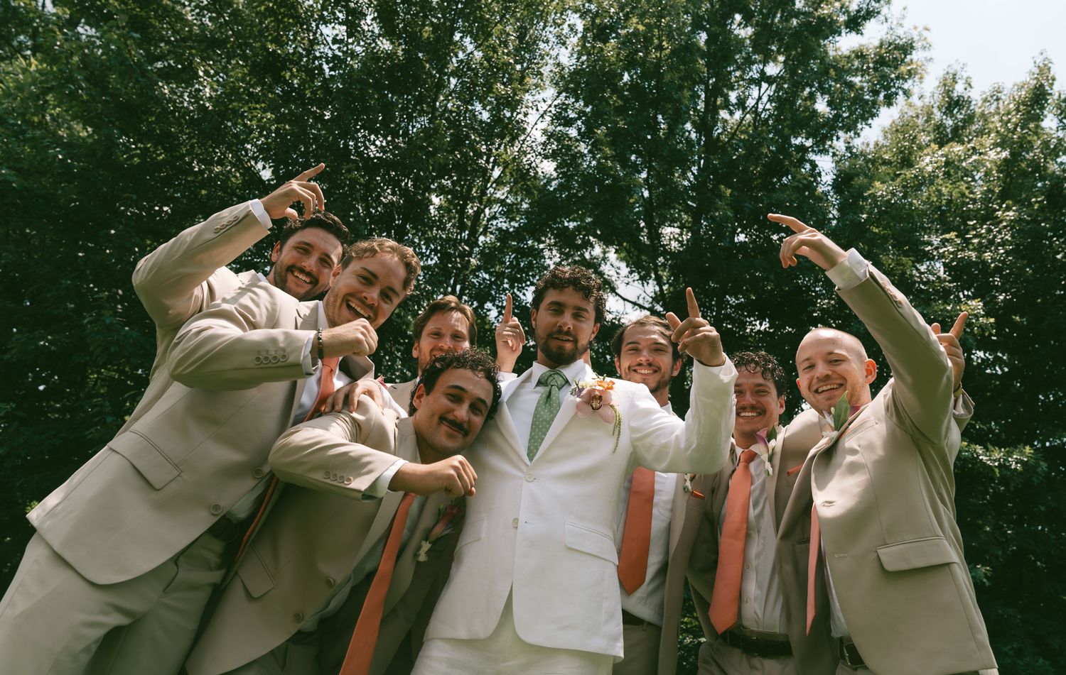 Wedding party group photo with people in white and beige outfits posing outdoors in. Pittsburgh, pa.