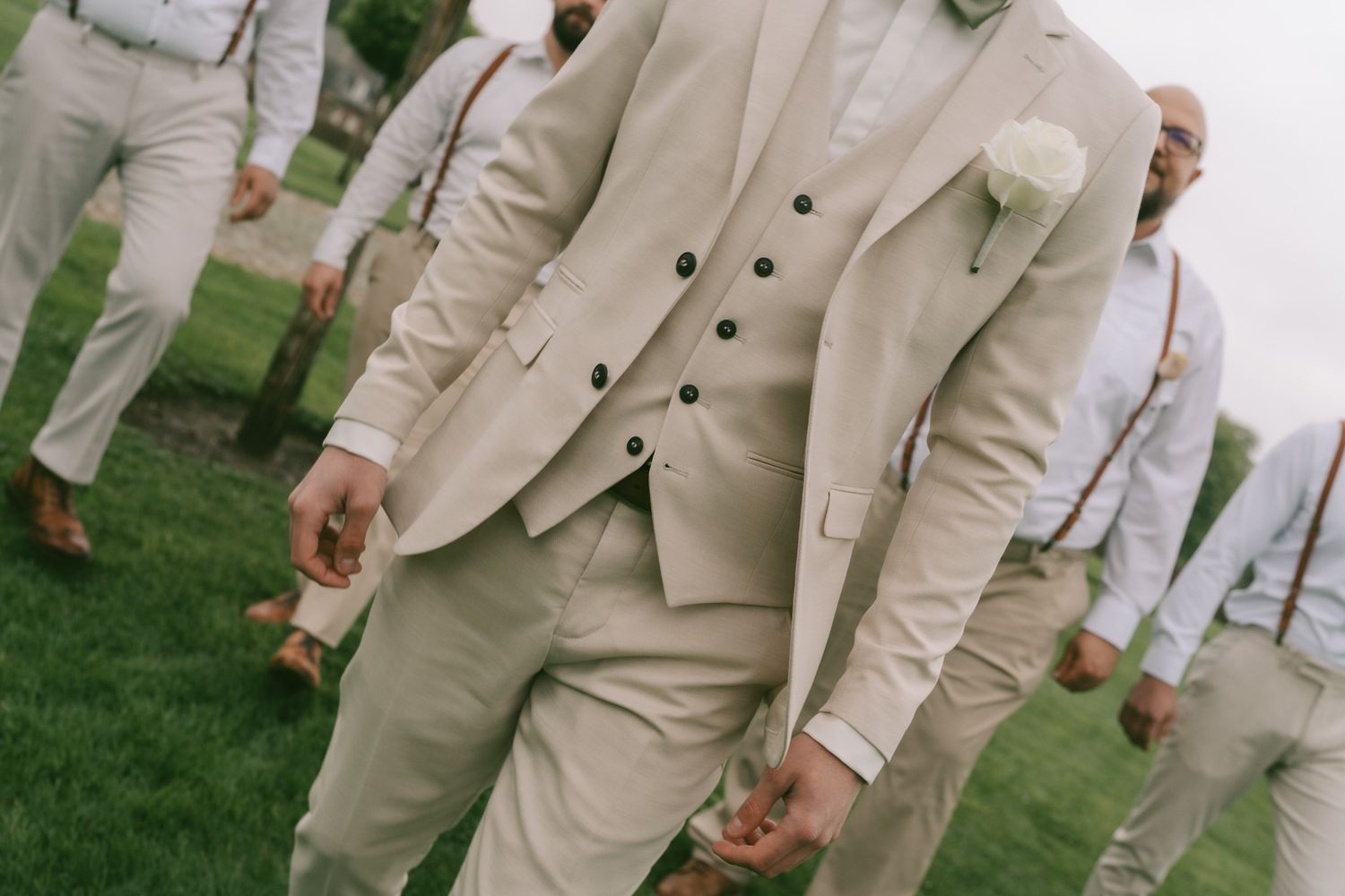 Group wearing matching cream-colored formal attire stands in an outdoor setting in Germany.