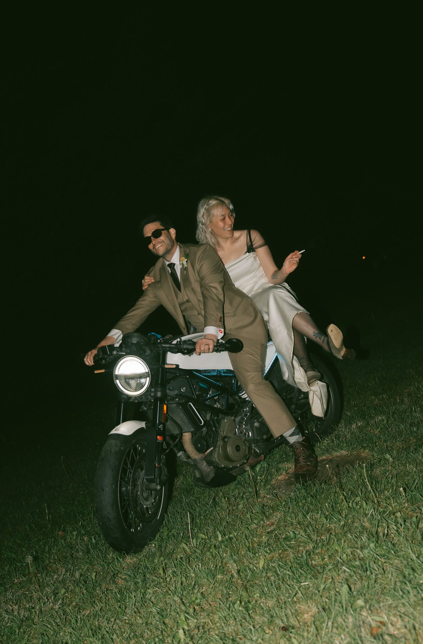 Adventurous wedding photo with couple on motorcycle at night on grassy field in Philedaphlia, pa .