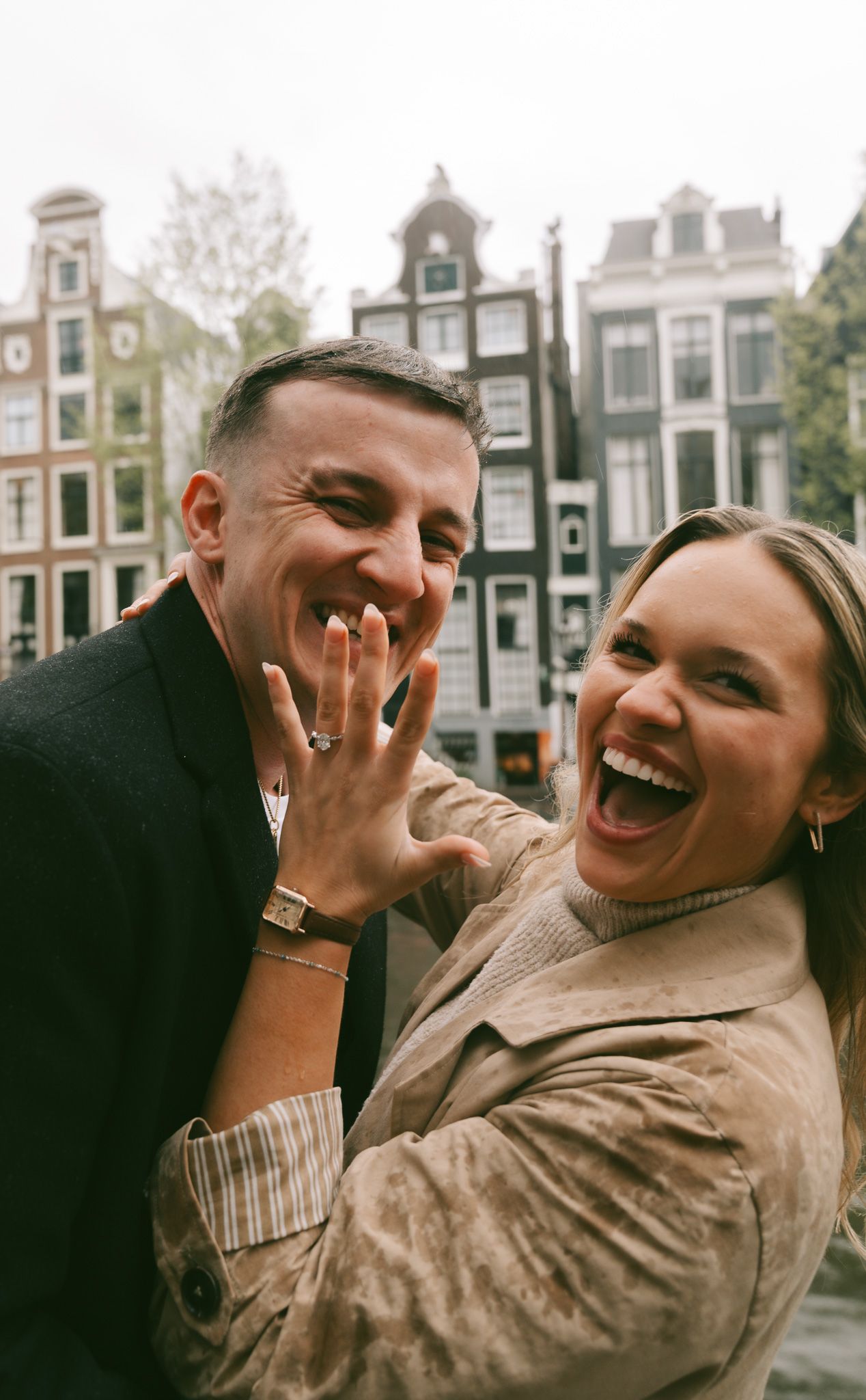 Candid moments of joy captured against classic Amsterdam canal houses.