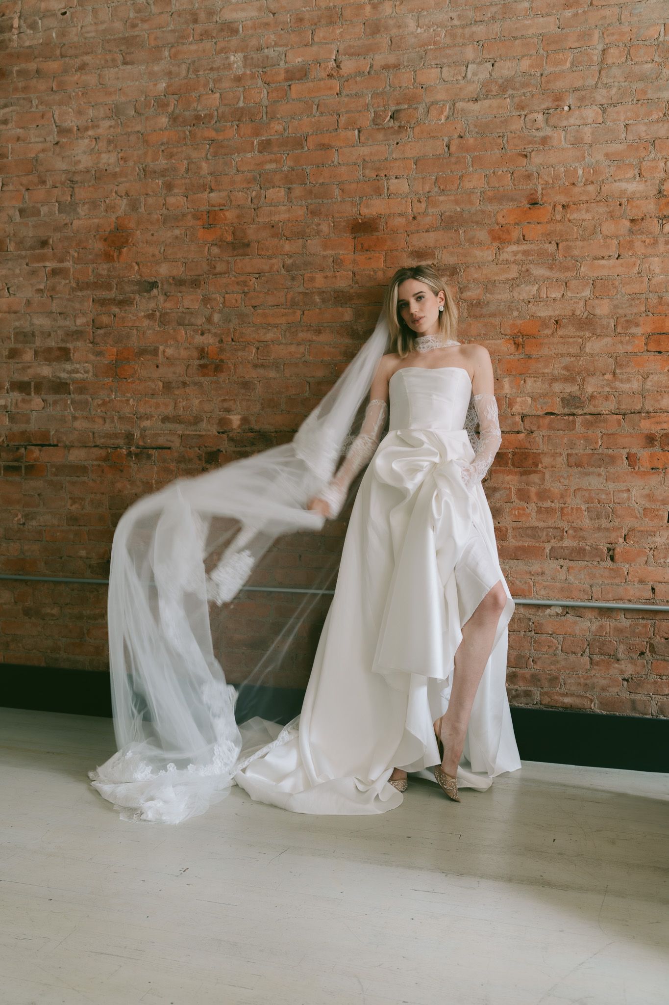 Elegant bridal session showcasing wedding dress movement against industrial brick background in Manhattan NYC