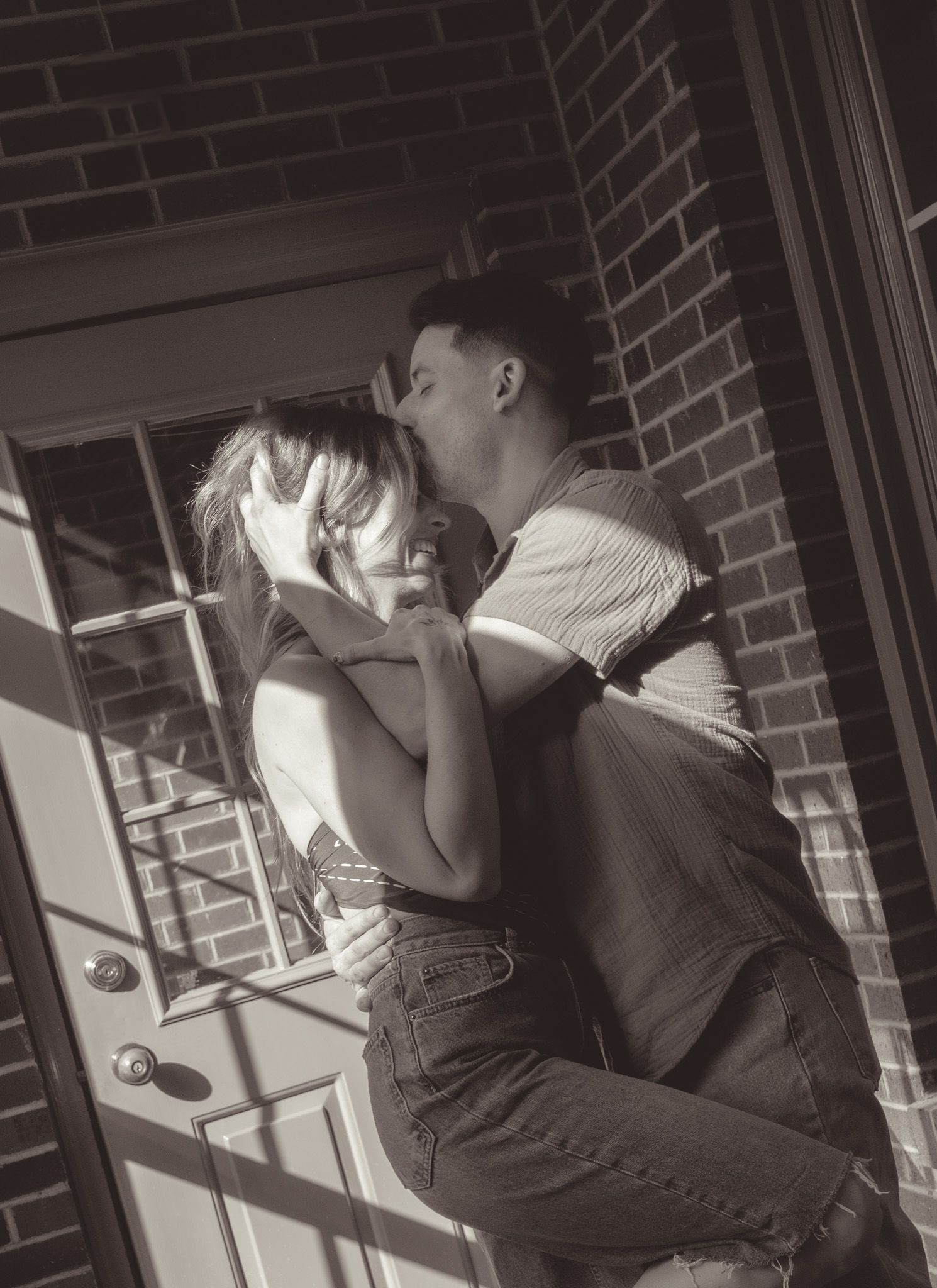 People climb and play on brick walls and window ledges in black and white.