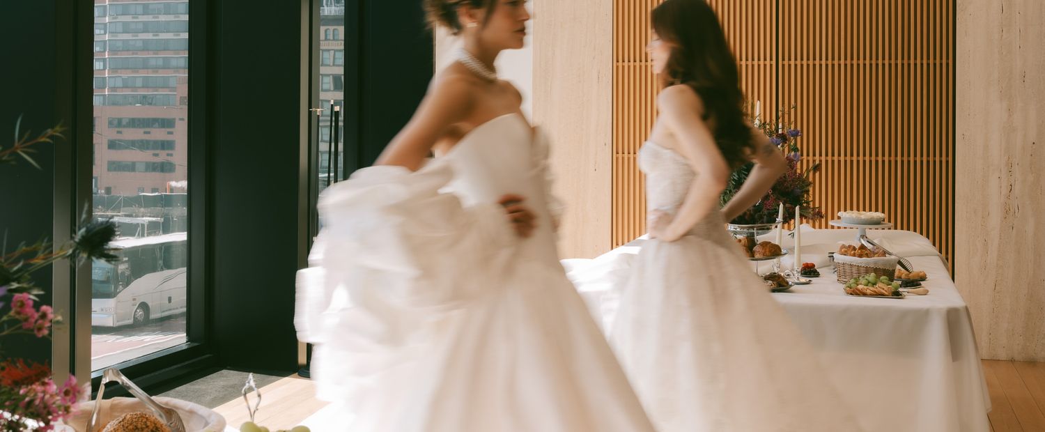 blurry photo of brides walking with off-white and champagne colored gowns in manhattan NYC.