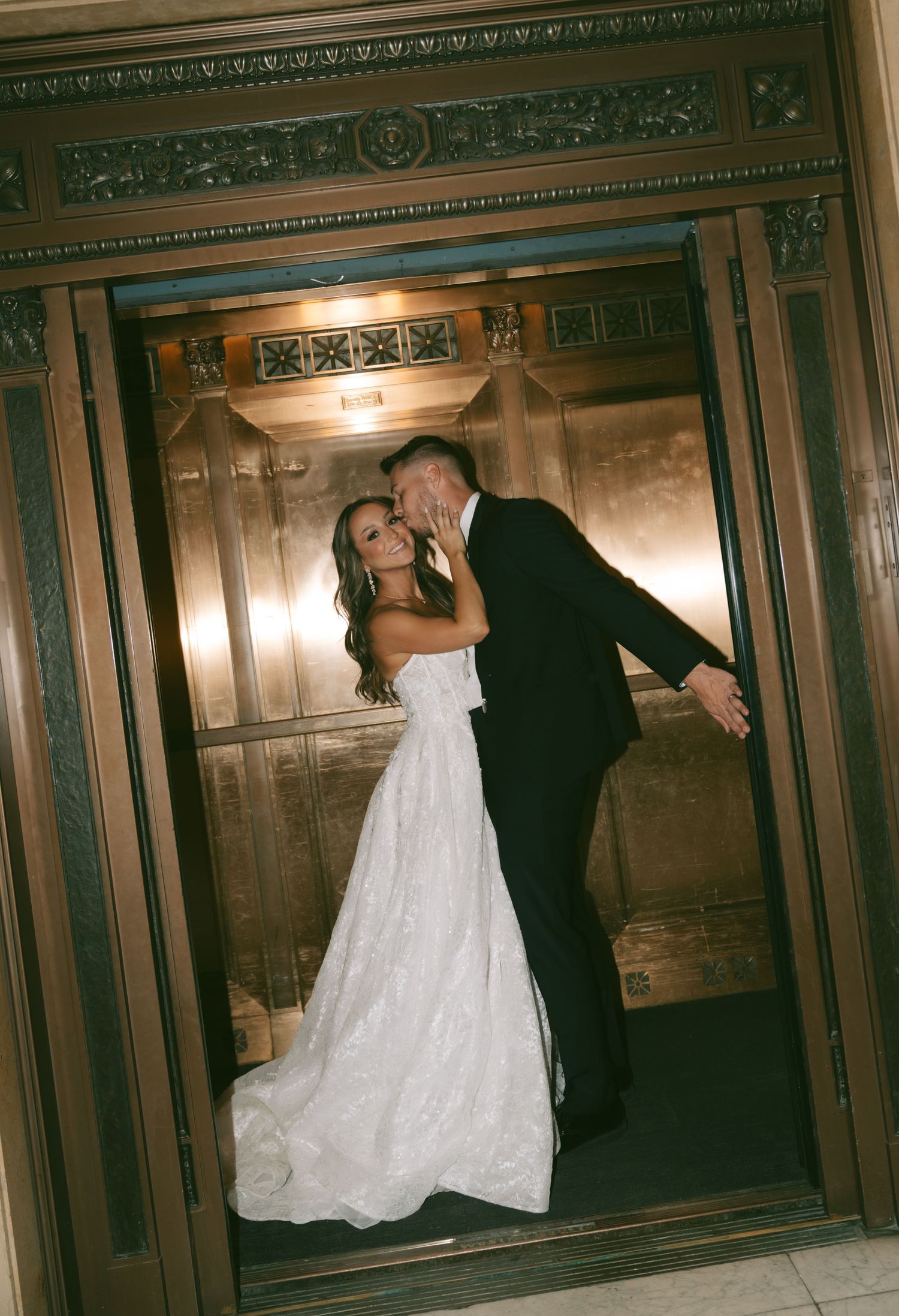 Newlyweds dance together in an ornate wood-paneled room with decorative molding.