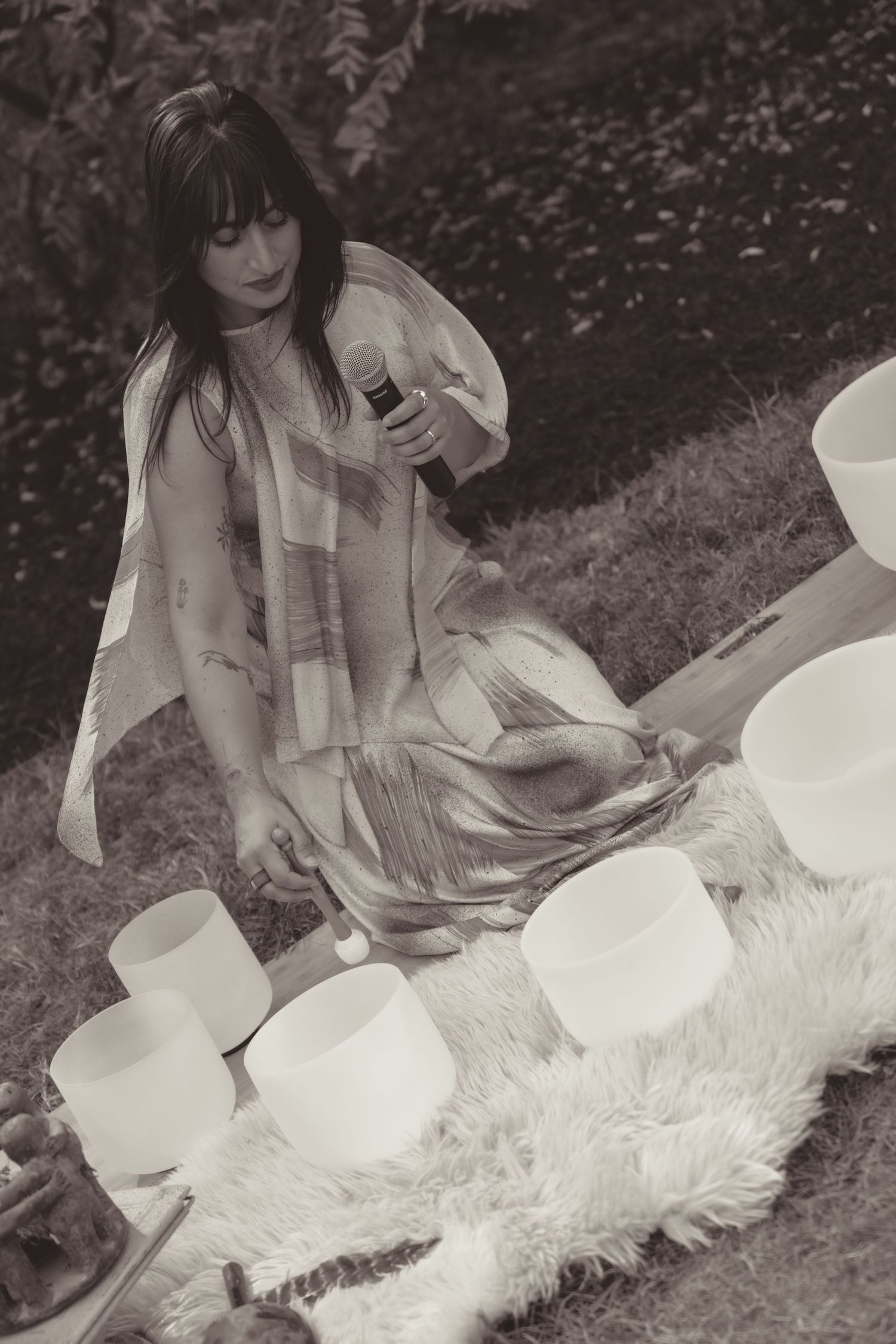 A black and white photo series shows someone in a white dress sitting on a fluffy rug outdoors.