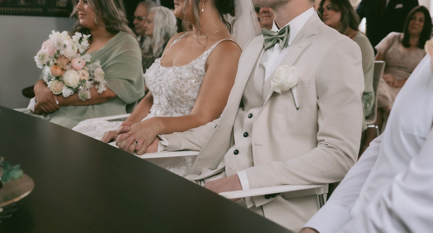 Wedding ceremony attendees seated in formal attire during an indoor service in Germany.