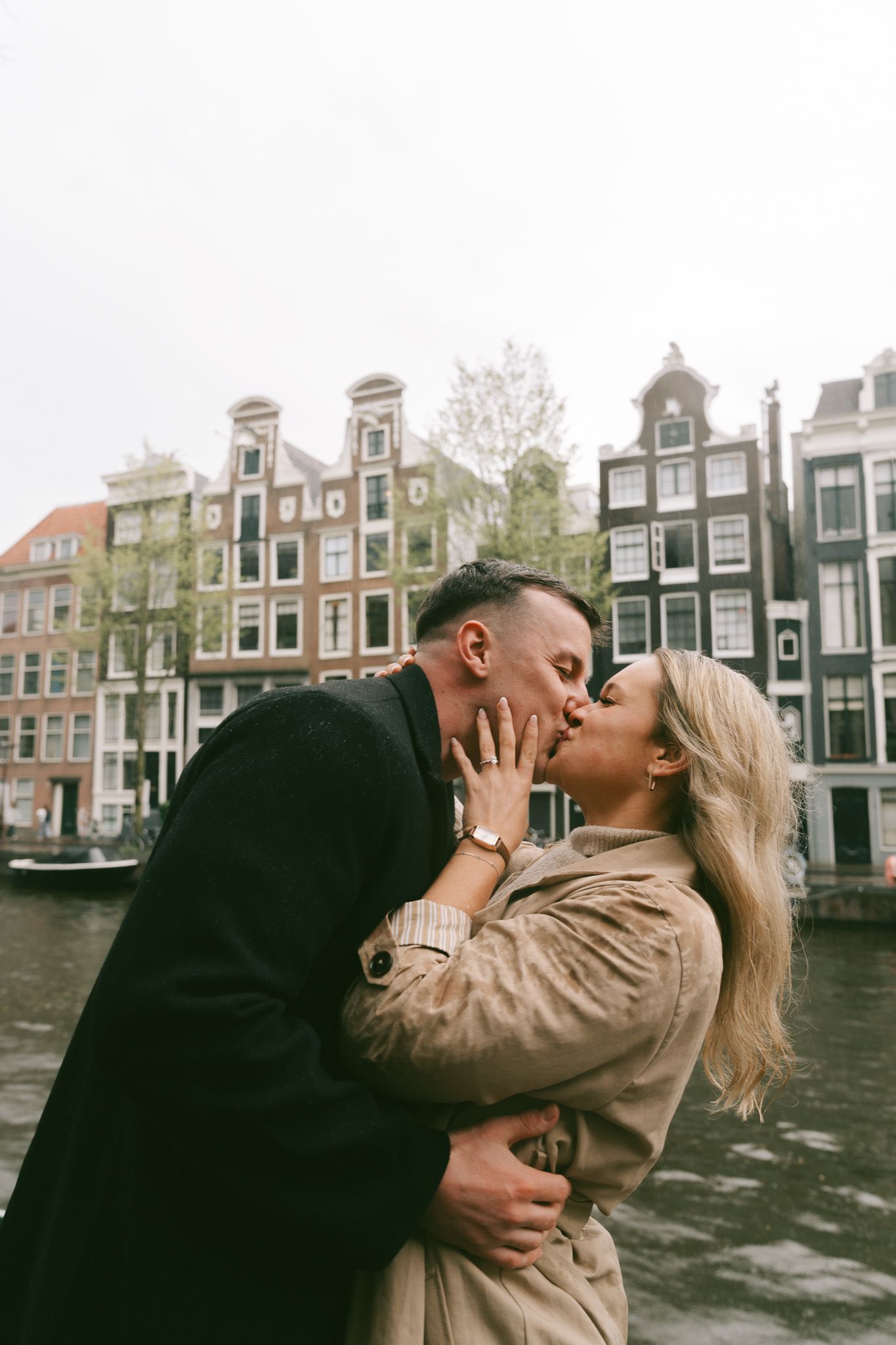 Romantic moment captured against the backdrop of Amsterdam's iconic canal houses.