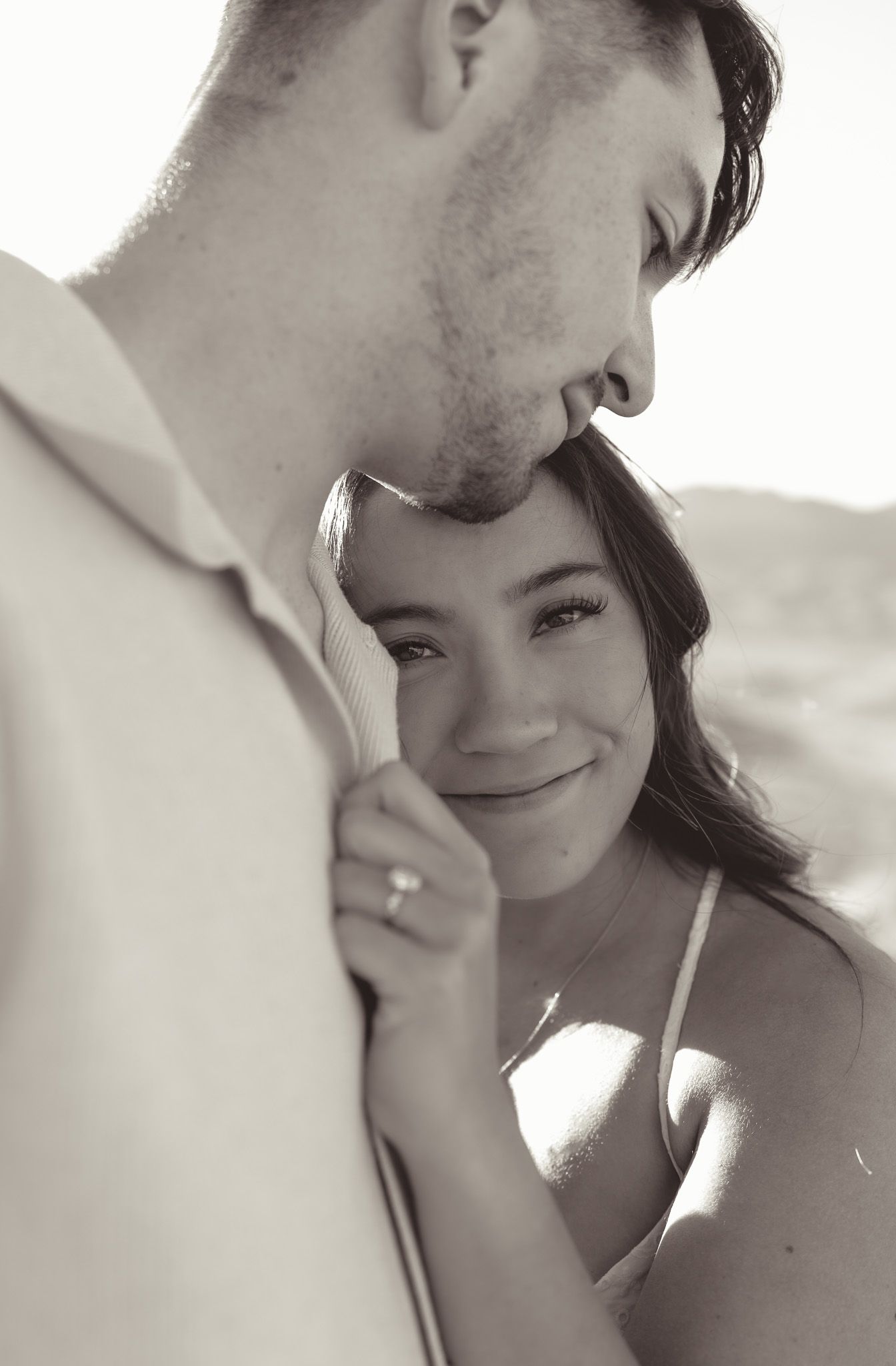 A romantic black and white close-up portrait of a couple sharing an intimate moment outdoors in red rock canyon, las vegas