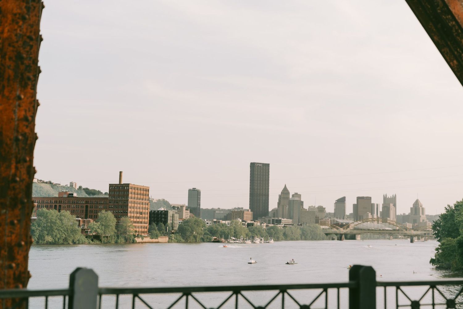 Panoramic cityscape view across a waterfront with modern buildings and towers in the distance.
