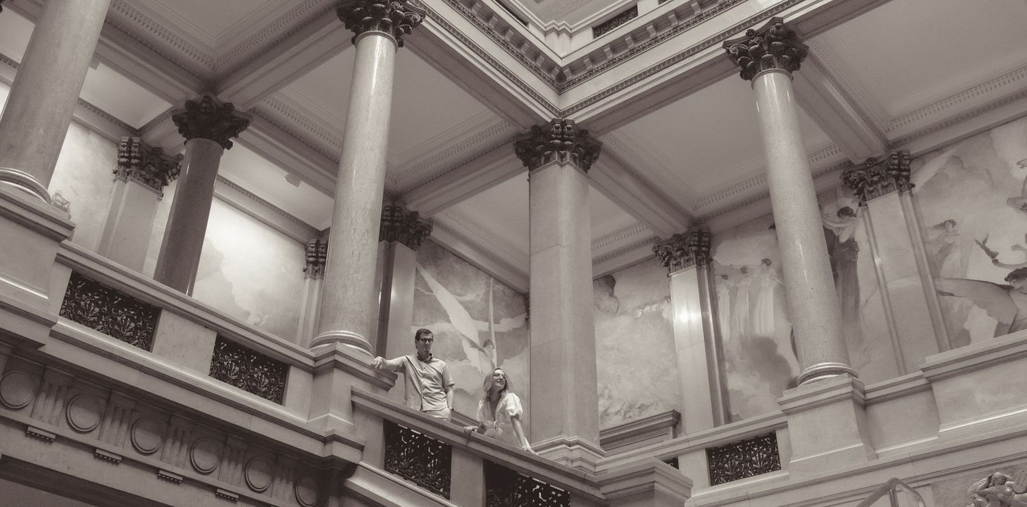 Interior architectural details of an ornate classical building with decorative ceiling moldings.