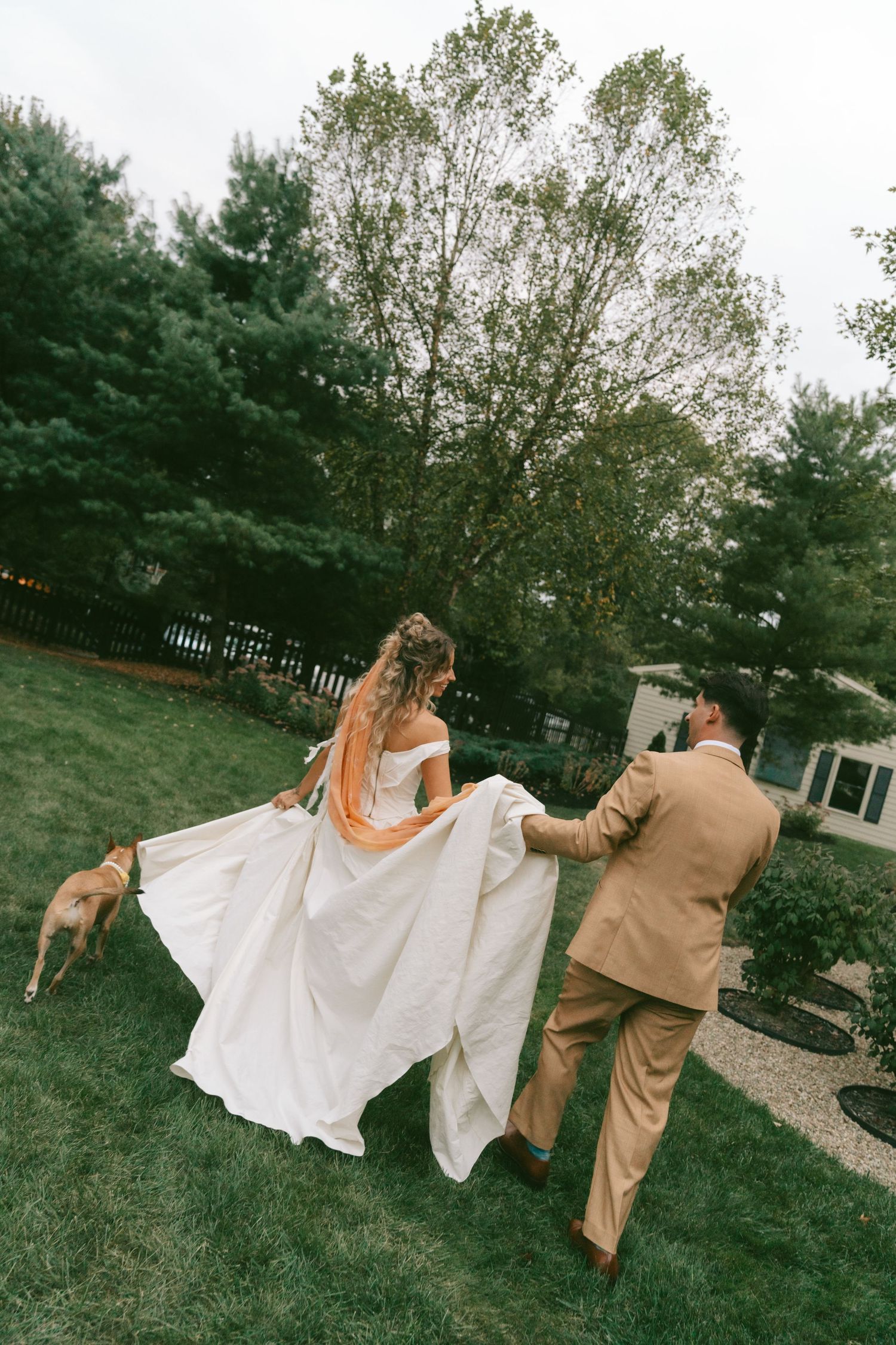 Playful outdoor wedding party poses in sequence showing movement across a green lawn.