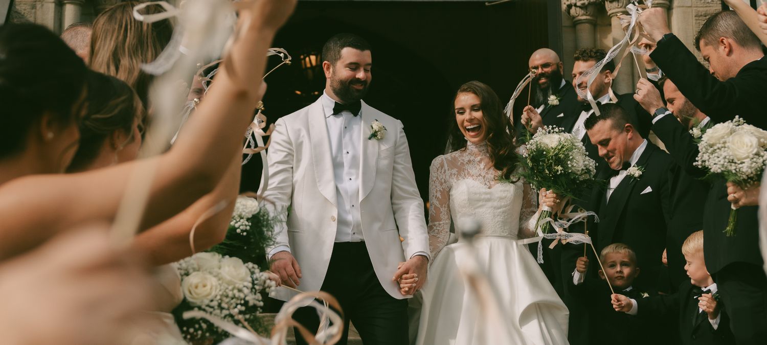 Wedding celebration scene with guests cheering for couple in formal attire in a downtown pittsburgh, pa church.