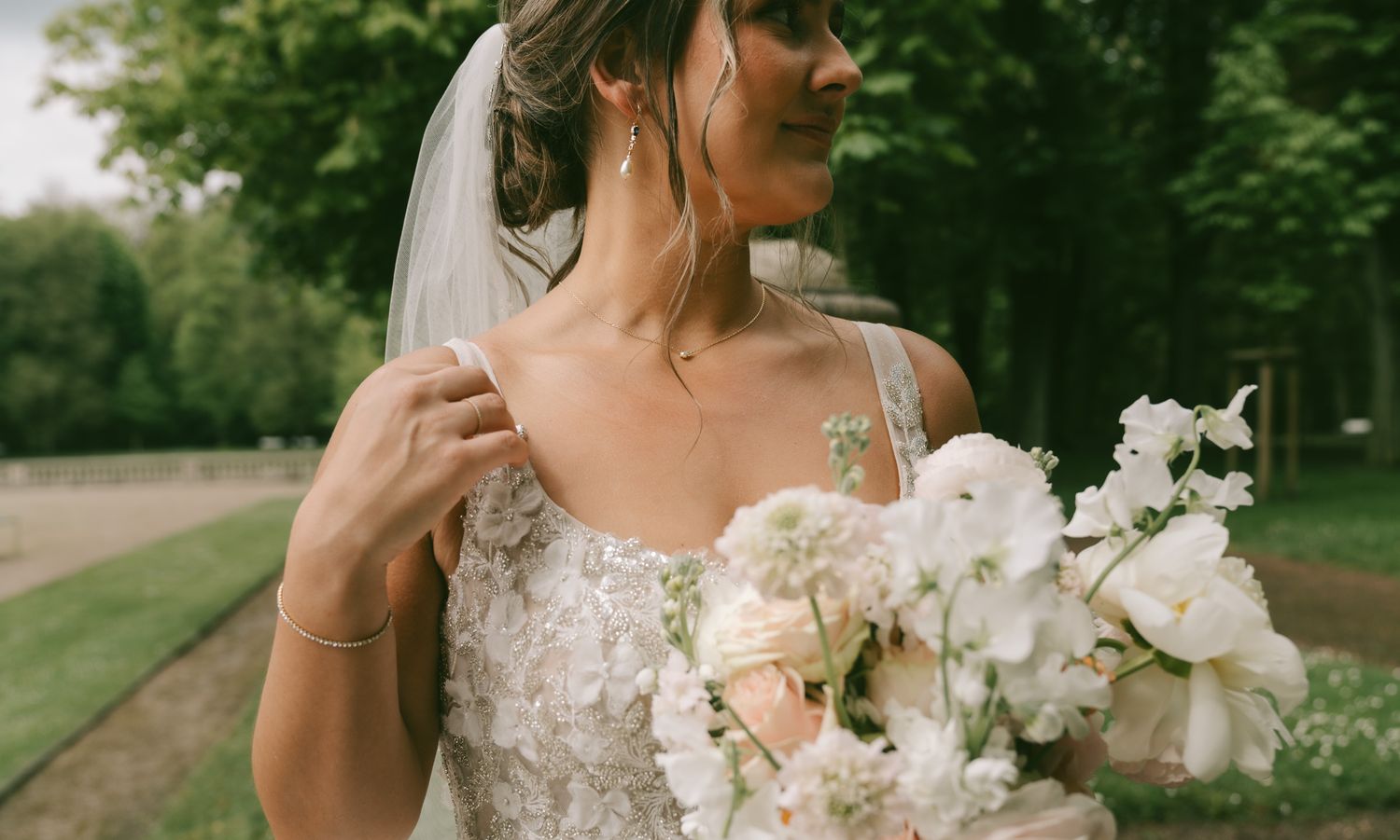 A romantic wedding photo featuring a couple in light-colored attire surrounded by greenery in Germany