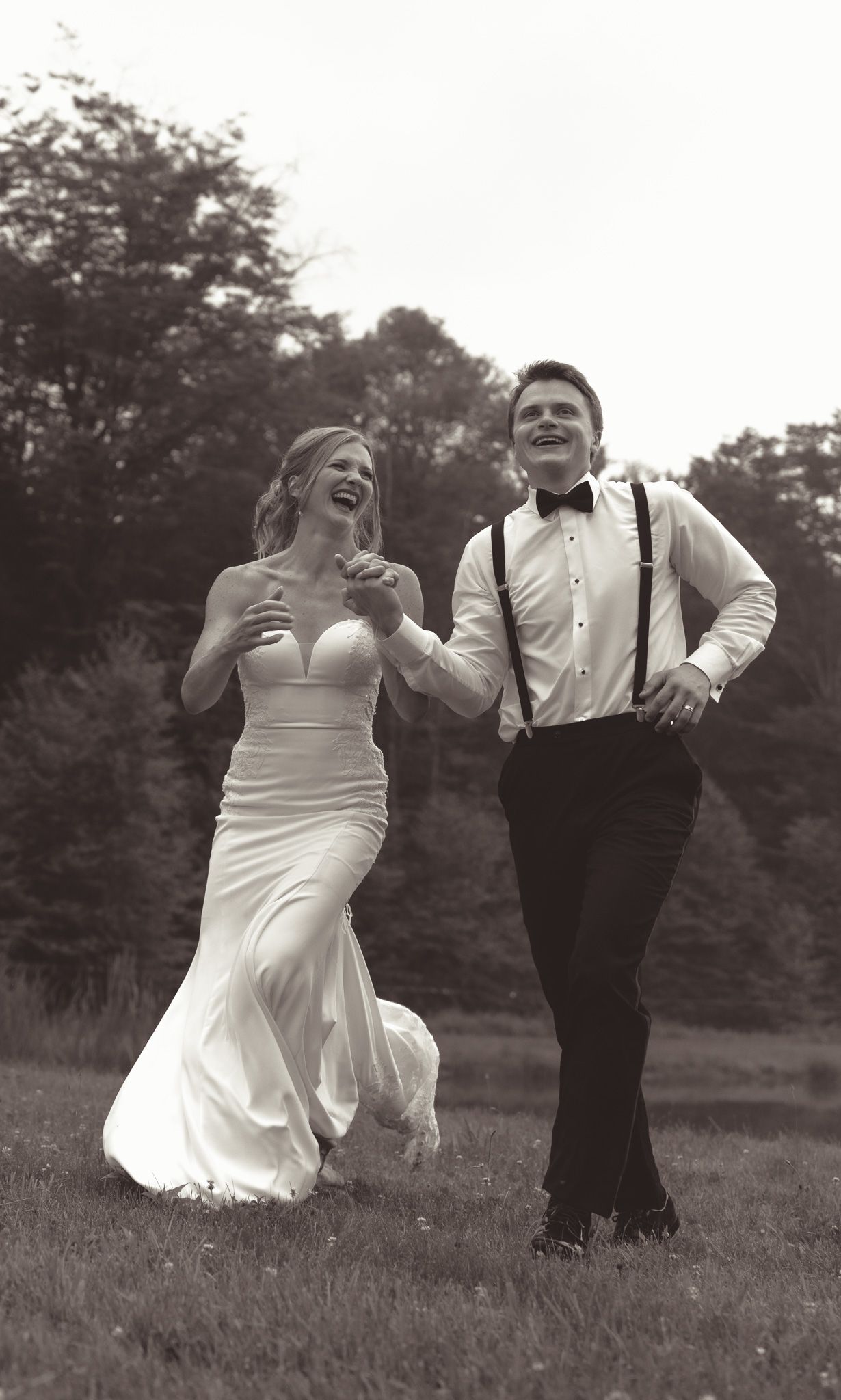 Black and white sequence of joyful couple dancing and laughing in a field.