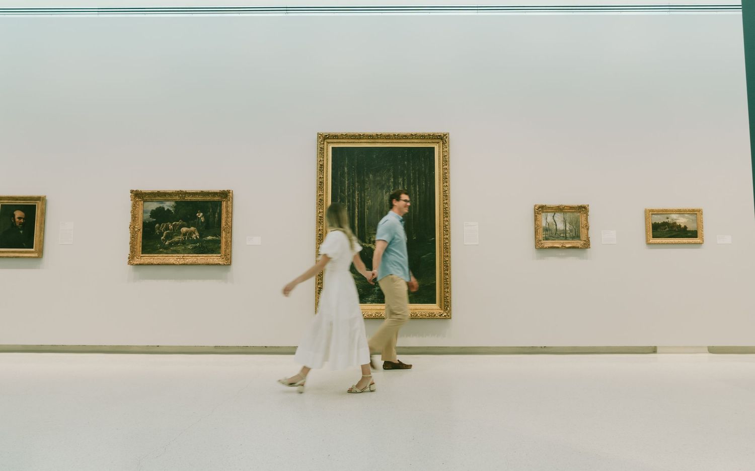 Minimalist gallery space with white walls and artwork displayed in sequence.
