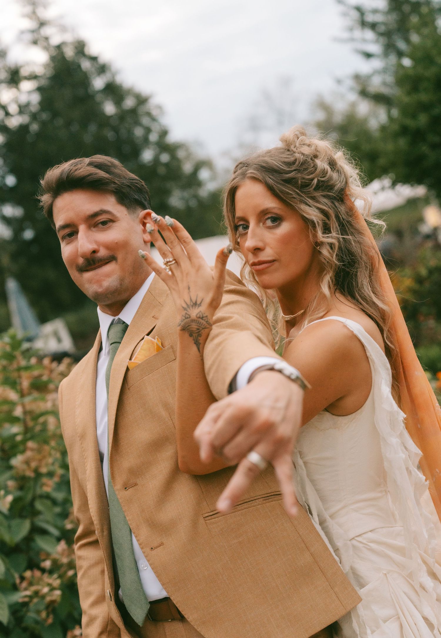 Candid dancing sequence showing joyful movements in formal wedding attire outdoors.