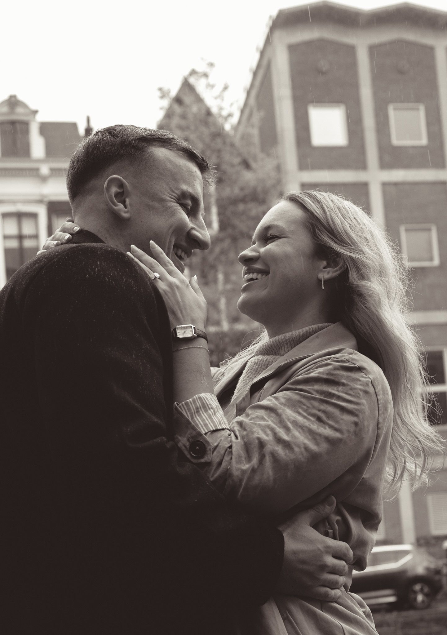 Romantic black and white sequence of a couple embracing against historic Amsterdam architecture.