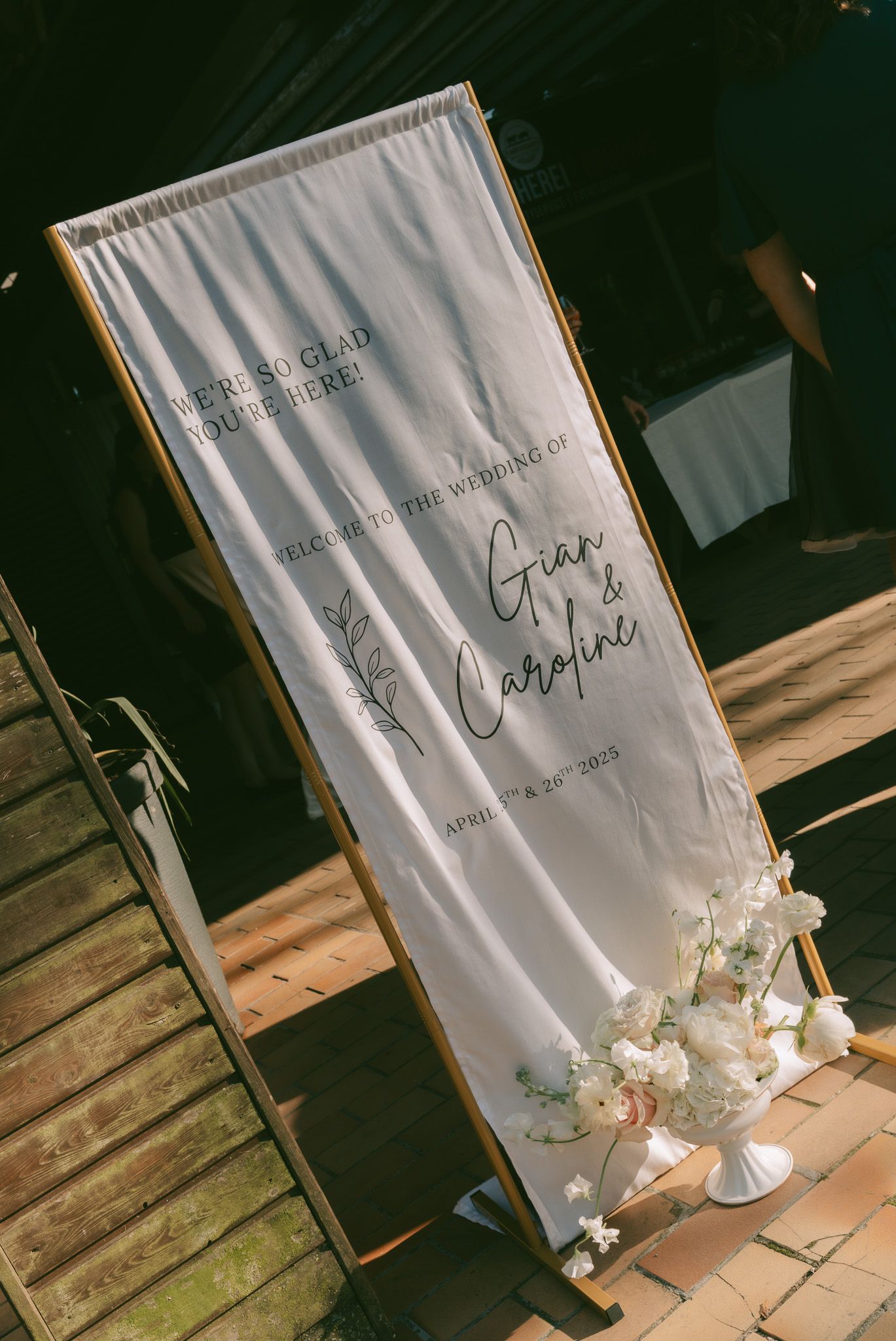 Elegant wedding event backdrop with white fabric and floral decorations.