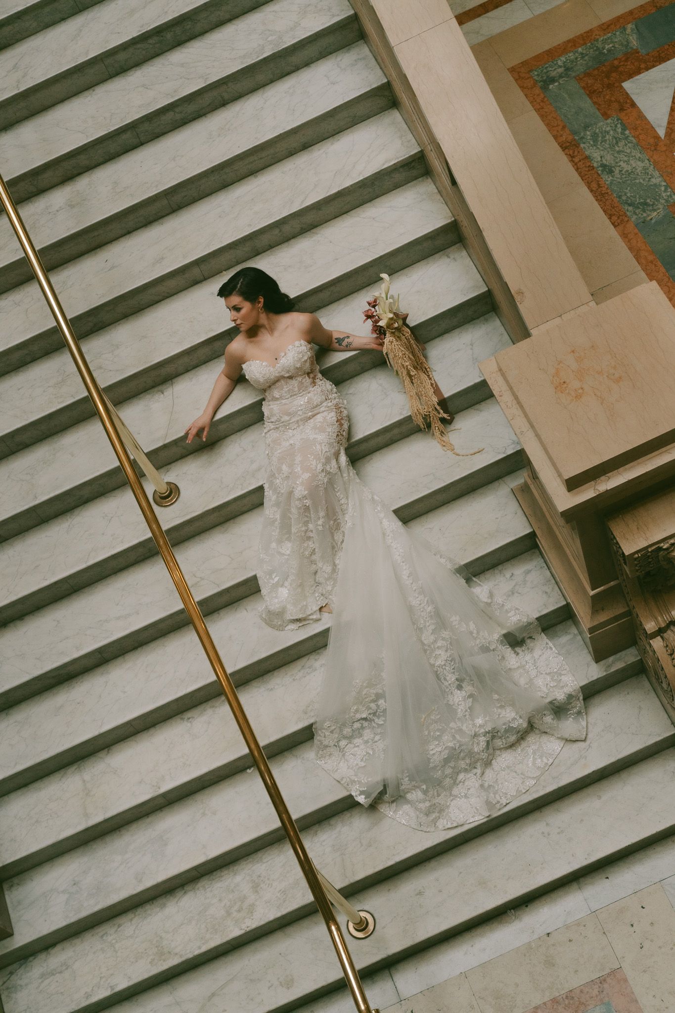 Overhead view of wedding dress trailing down geometric staircase pattern at Carnegie Museum in Pittsburgh, pa.