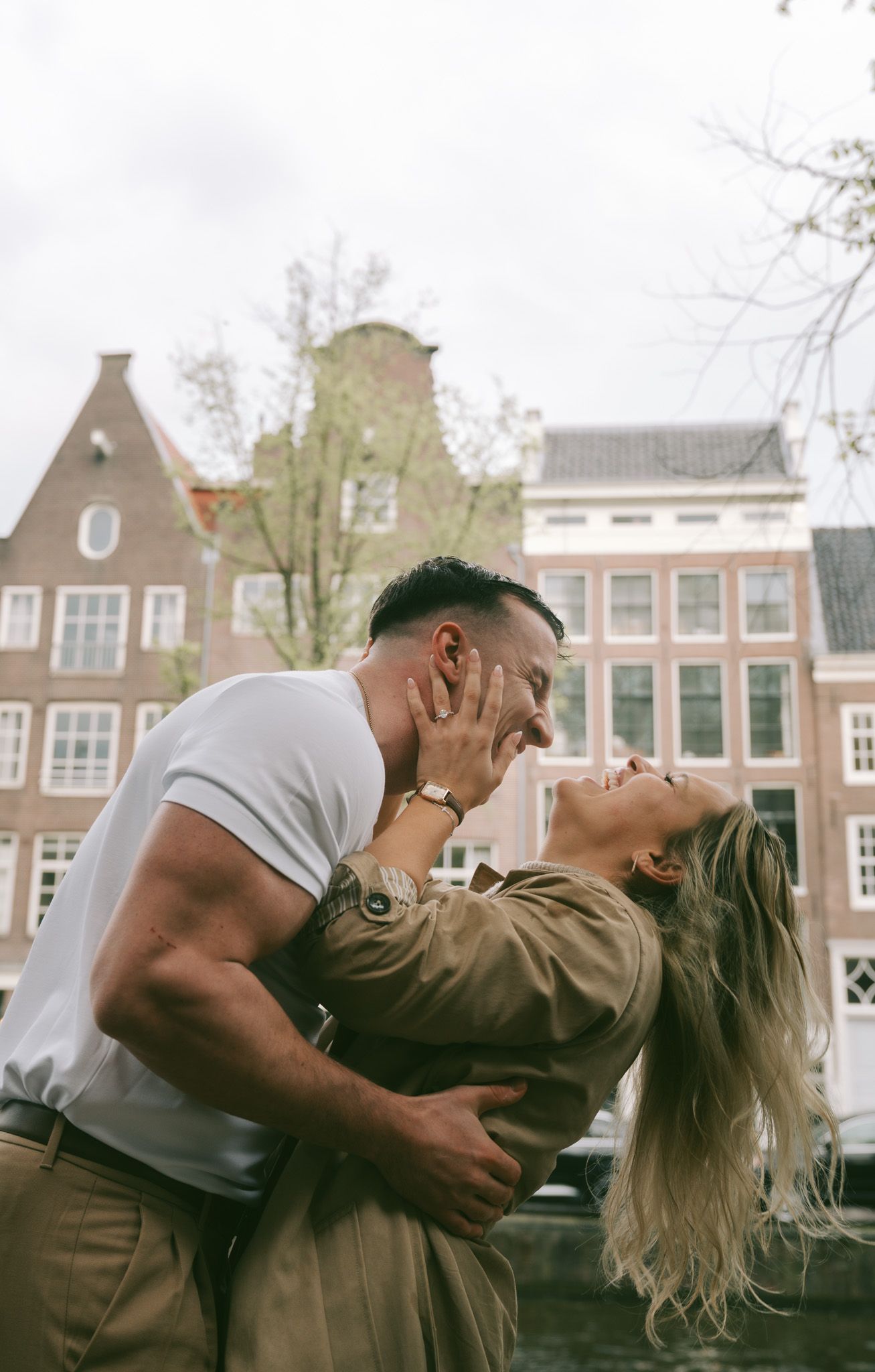Romantic scene with traditional Dutch canal houses creating a picturesque backdrop in Amsterdam.